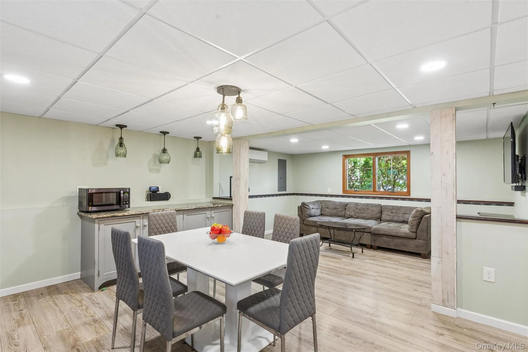 Versatile lower-level space featuring recessed lighting, and a built-in wet bar with a stone countertop Versatile lower-level space featuring recessed lighting, and a built-in wet bar with a stone countertop