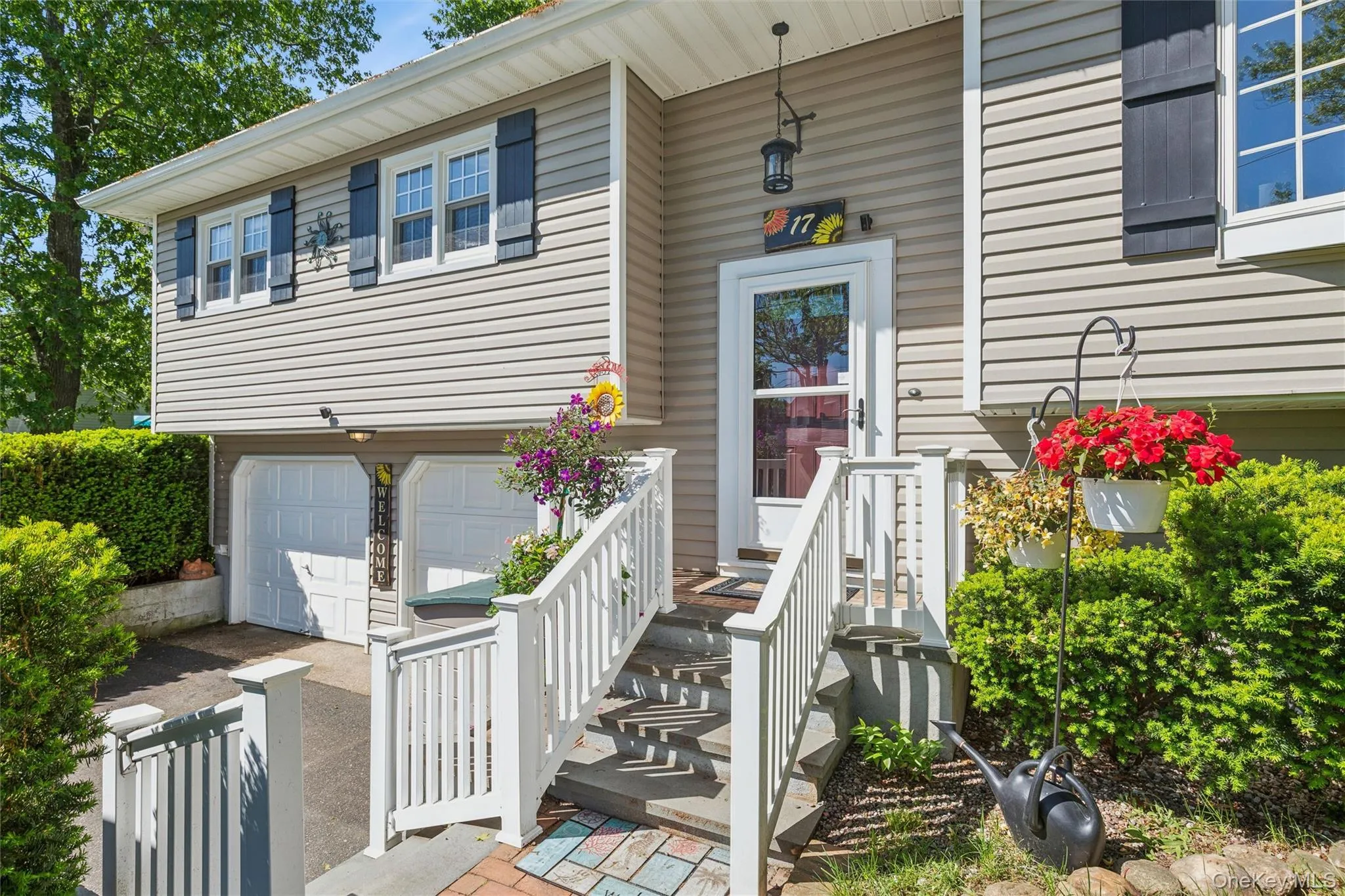Inviting front entrance featuring gray siding, white trim, and black window shutters Inviting front entrance featuring gray siding, white trim, and black window shutters