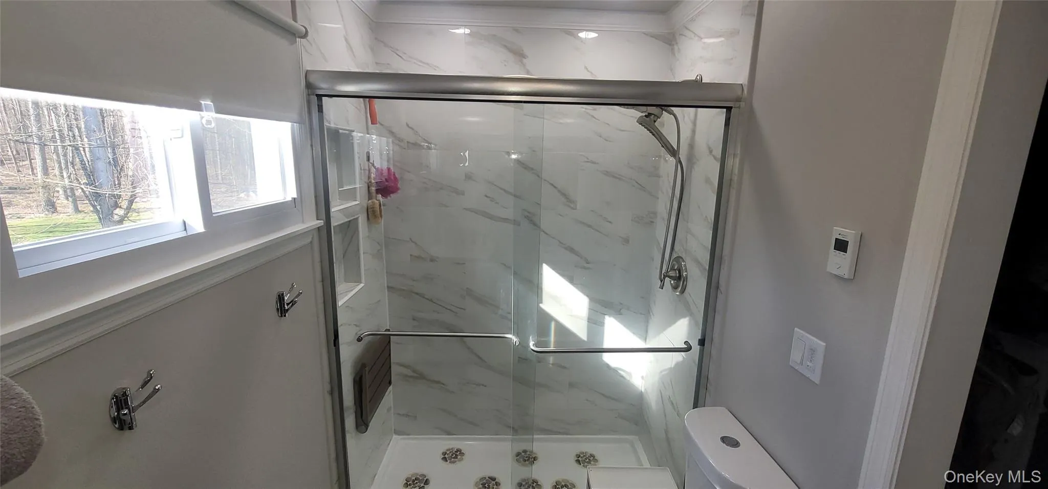 Bathroom with toilet and a marble finish shower Bathroom with toilet and a marble finish shower