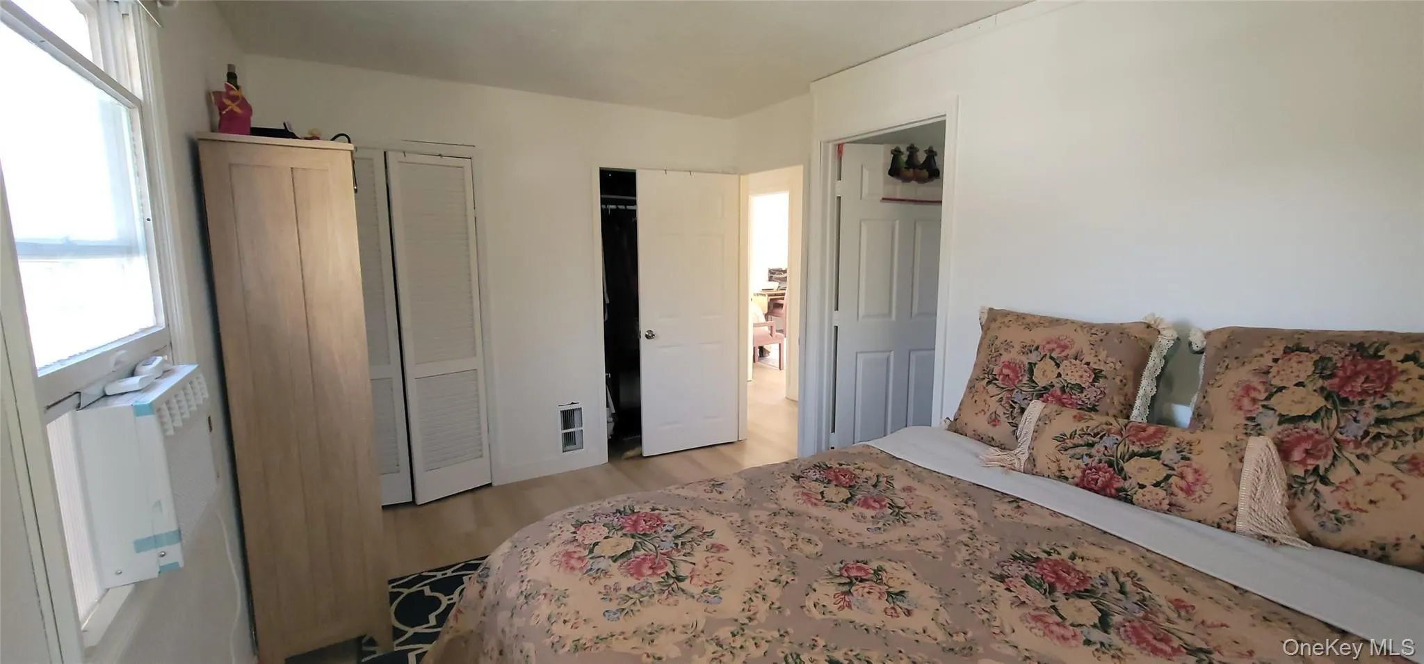Bedroom with multiple windows, light wood-style floors Bedroom with multiple windows, light wood-style floors