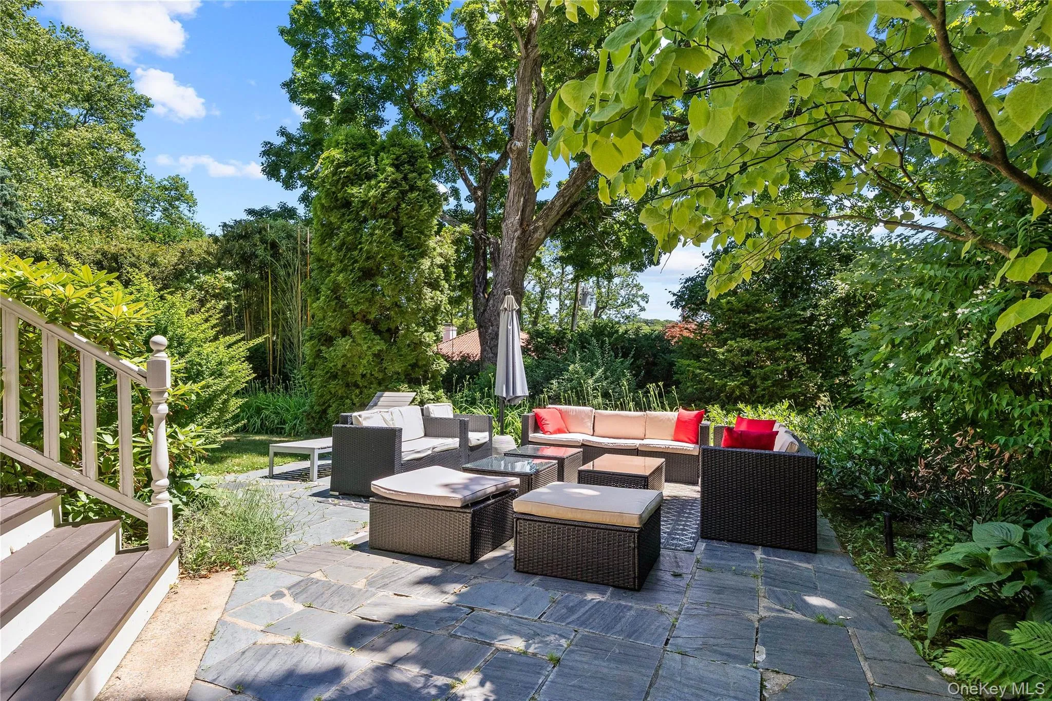 Expansive outdoor patio featuring flagstone paving and mature perimeter landscaping Expansive outdoor patio featuring flagstone paving and mature perimeter landscaping