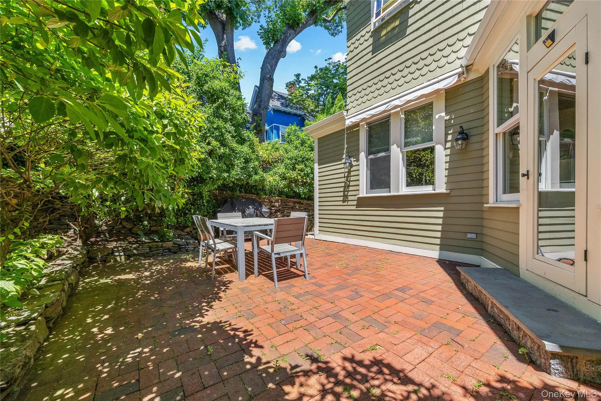 Expansive brick patio bordered by stone retaining walls Expansive brick patio bordered by stone retaining walls