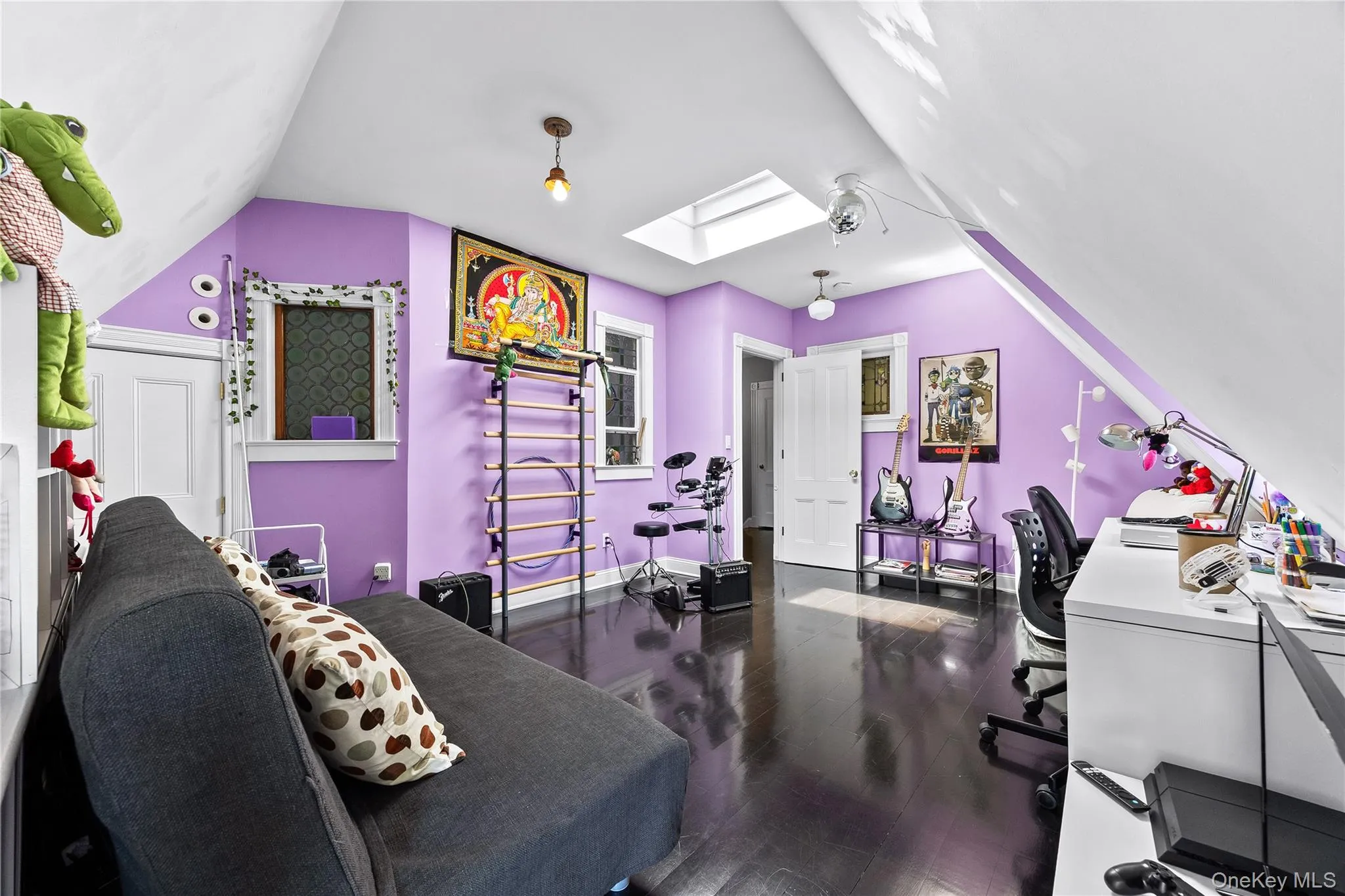 Attic-level room featuring rich wood-finish flooring and a bright skylight Attic-level room featuring rich wood-finish flooring and a bright skylight