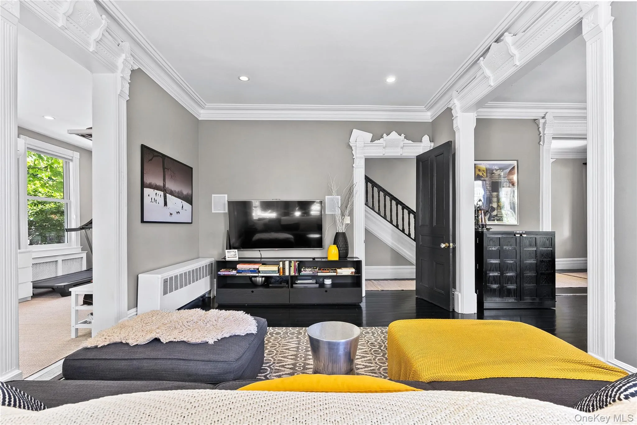 Living area featuring high ceilings, dark wood-finish flooring, decorative crown molding, and recessed lighting Living area featuring high ceilings, dark wood-finish flooring, decorative crown molding, and recessed lighting