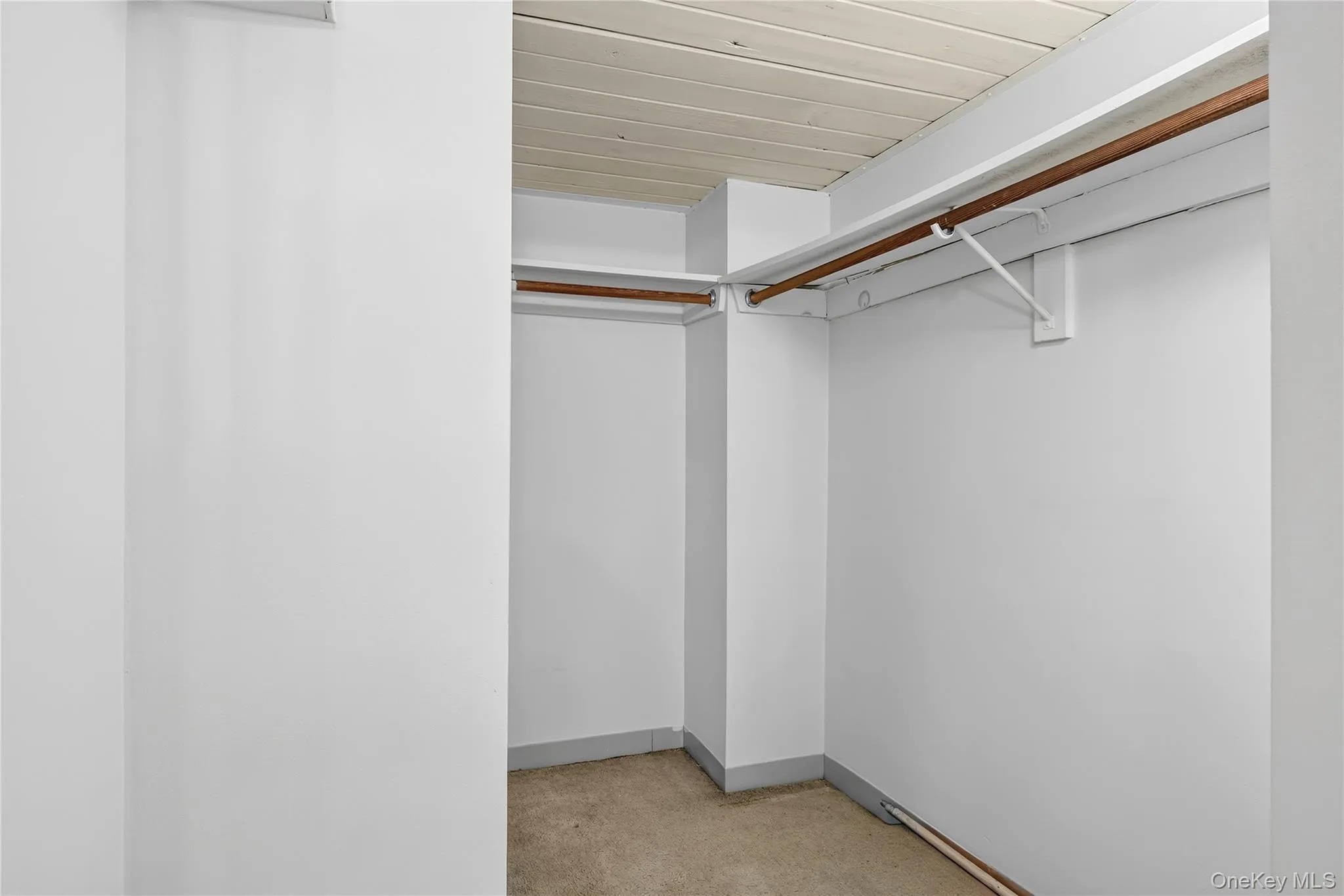 White-painted interior space featuring a light-toned ceiling, white walls, and a carpeted floor White-painted interior space featuring a light-toned ceiling, white walls, and a carpeted floor