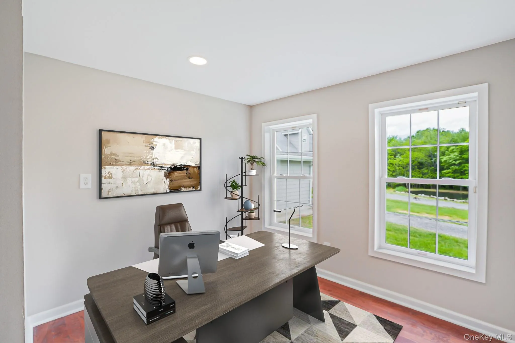 Dedicated room featuring two double-hung windows with white trim, recessed lighting, and wood-finish flooring Dedicated room featuring two double-hung windows with white trim, recessed lighting, and wood-finish flooring