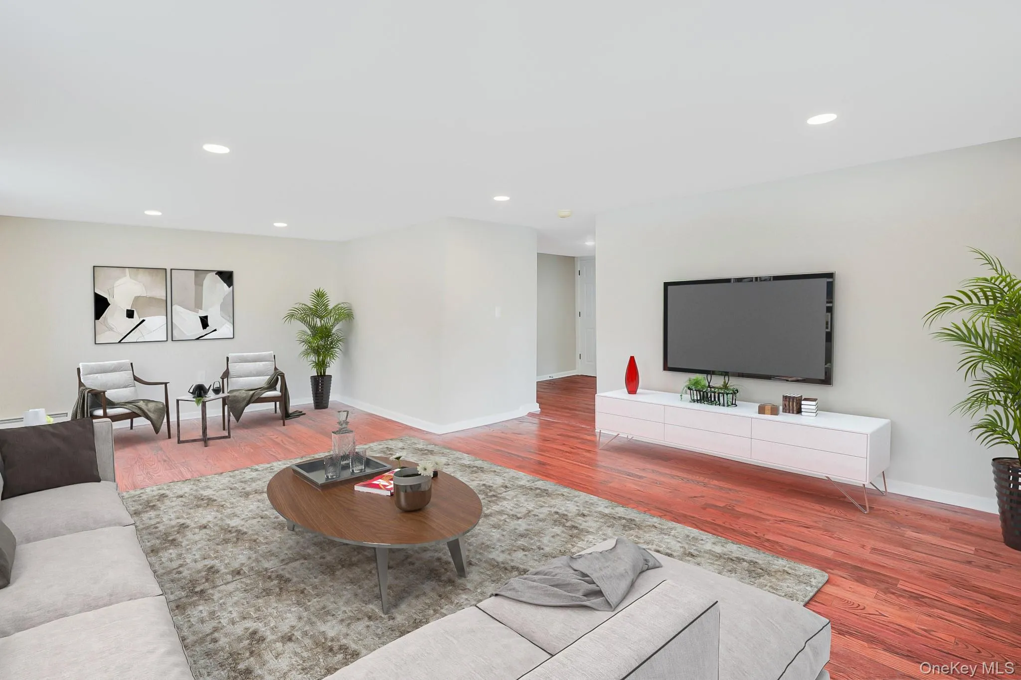 Spacious living area featuring rich wood-finish flooring, recessed lighting, and light neutral wall colors Spacious living area featuring rich wood-finish flooring, recessed lighting, and light neutral wall colors