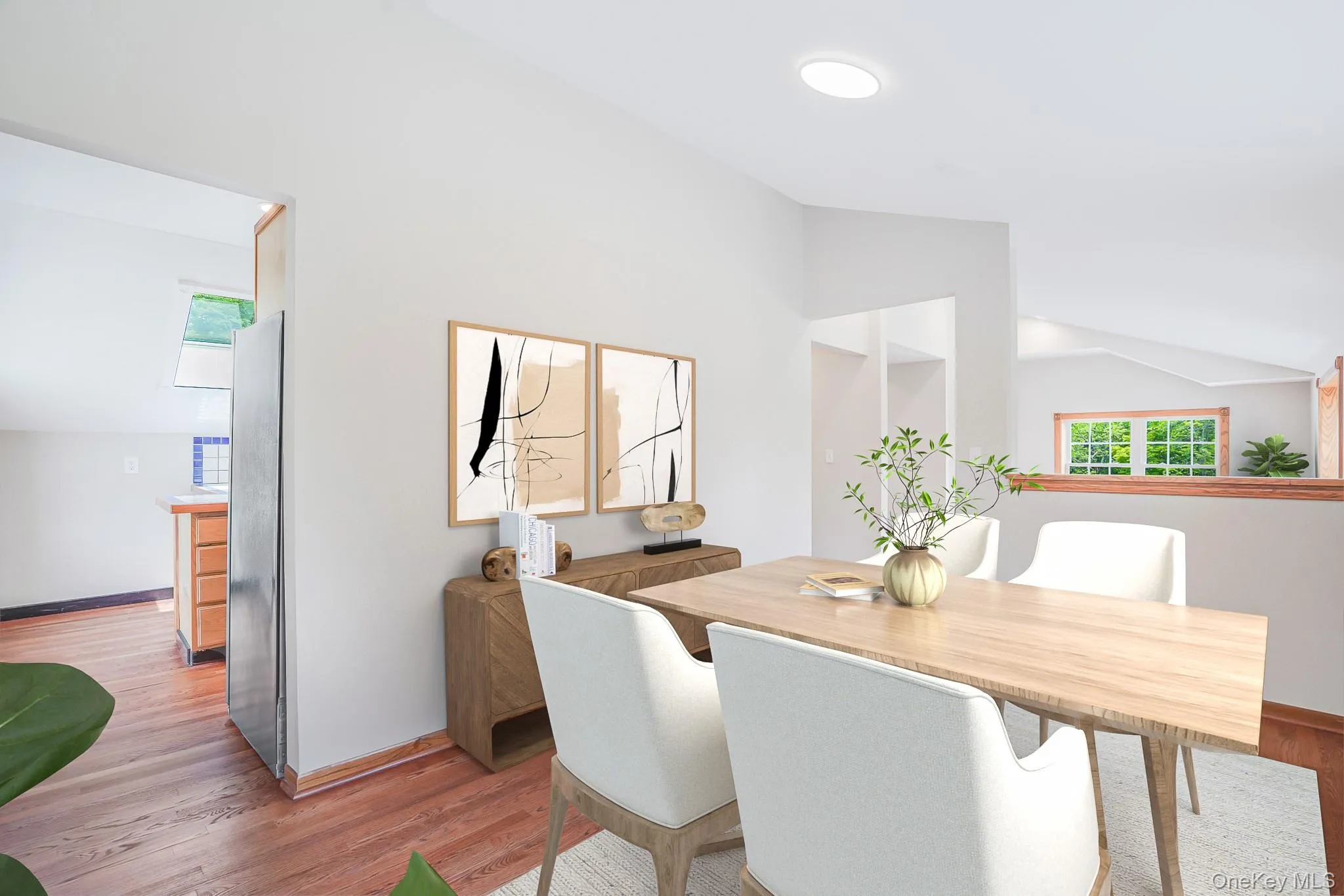Dining space featuring a vaulted ceiling and wood-finish flooring Dining space featuring a vaulted ceiling and wood-finish flooring
