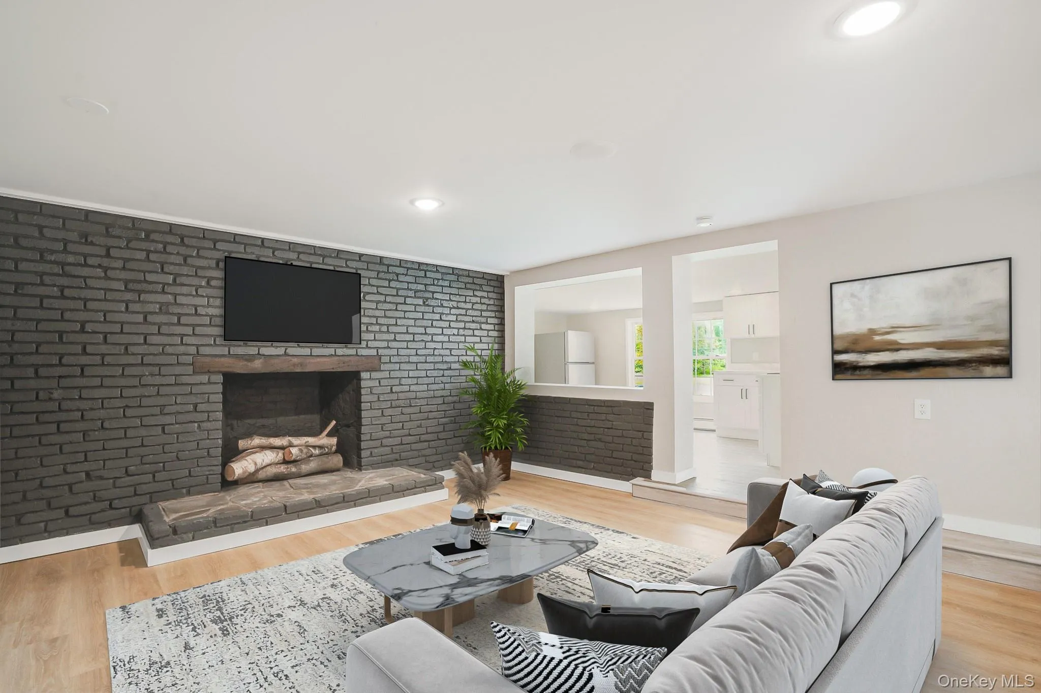 Living area featuring a floor-to-ceiling brick fireplace with a wood mantel Living area featuring a floor-to-ceiling brick fireplace with a wood mantel