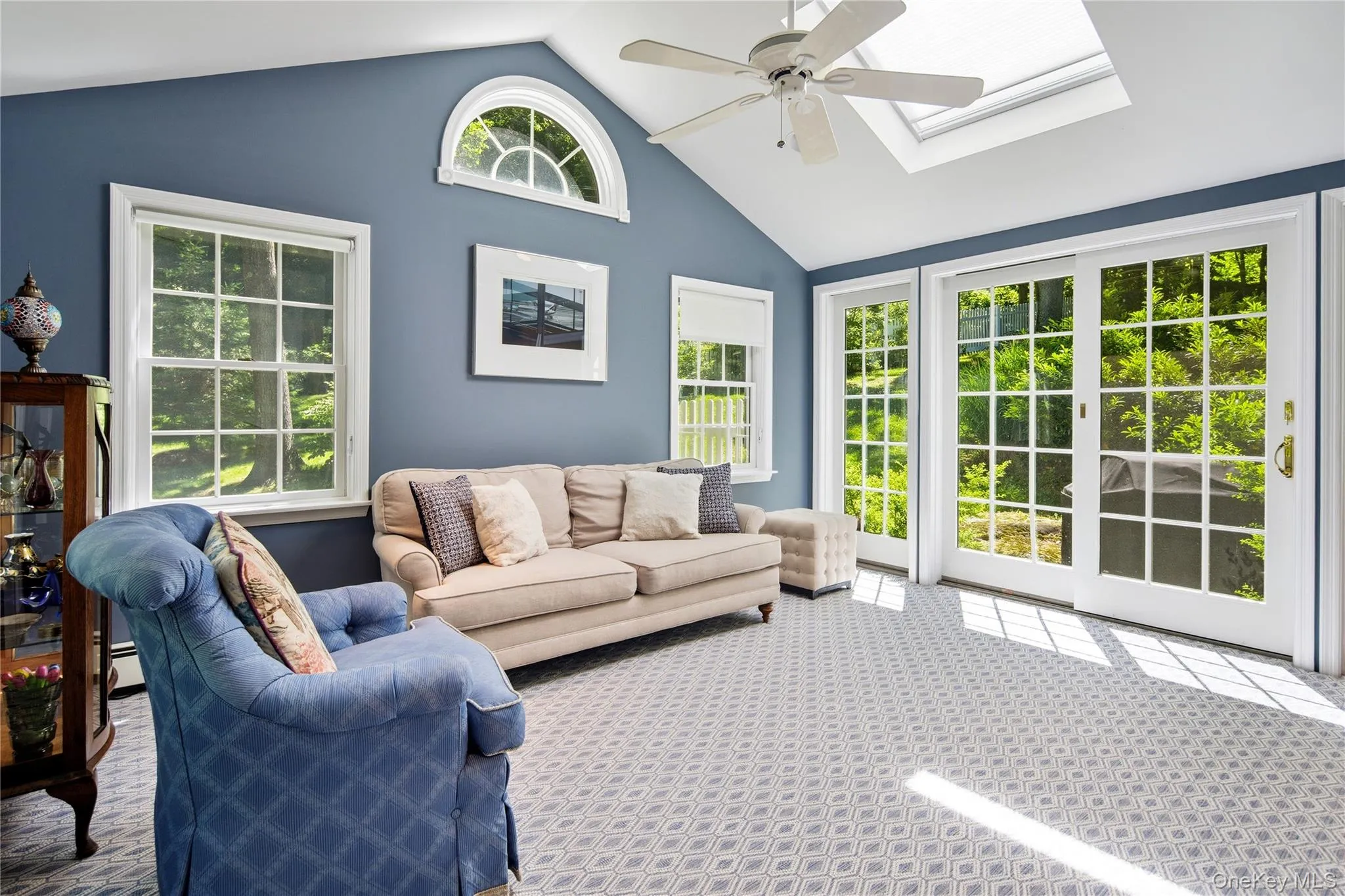 Family room open to the kitchen features vaulted ceiling with skylight, demi-lune clerestory window, French doors with sidelights, ceiling fan, wool wall-to-wall carpet. Family room open to the kitchen features vaulted ceiling with skylight, demi-lune clerestory window, French doors with sidelights, ceiling fan, wool wall-to-wall carpet.