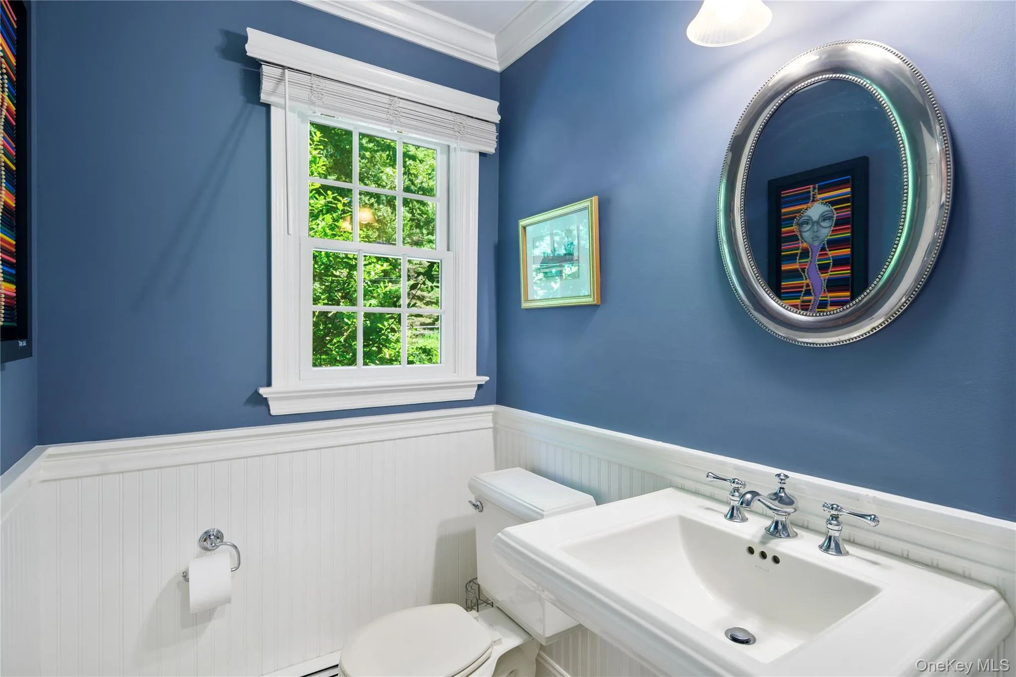 Windowed powder room features Kohler memoirs series pedestal sink and toilet, beadboard wainscoting, crown molding and wall sconce Windowed powder room features Kohler memoirs series pedestal sink and toilet, beadboard wainscoting, crown molding and wall sconce