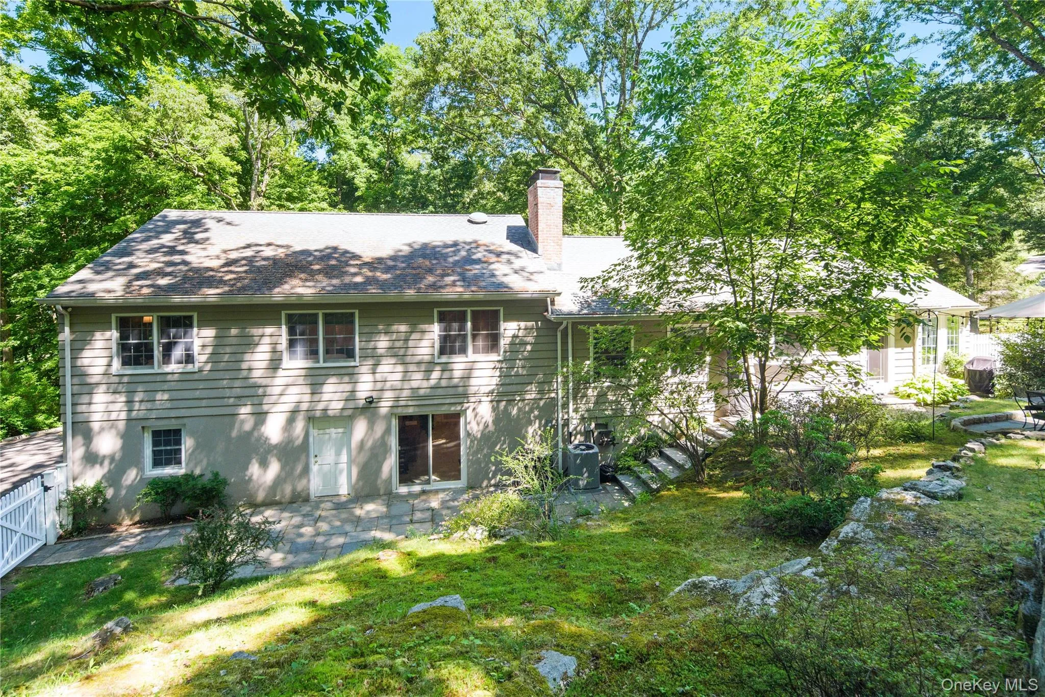 The lower level recreation room features sliding glass doors open to the patio, rock outcroppings provide texture and visual interest The lower level recreation room features sliding glass doors open to the patio, rock outcroppings provide texture and visual interest
