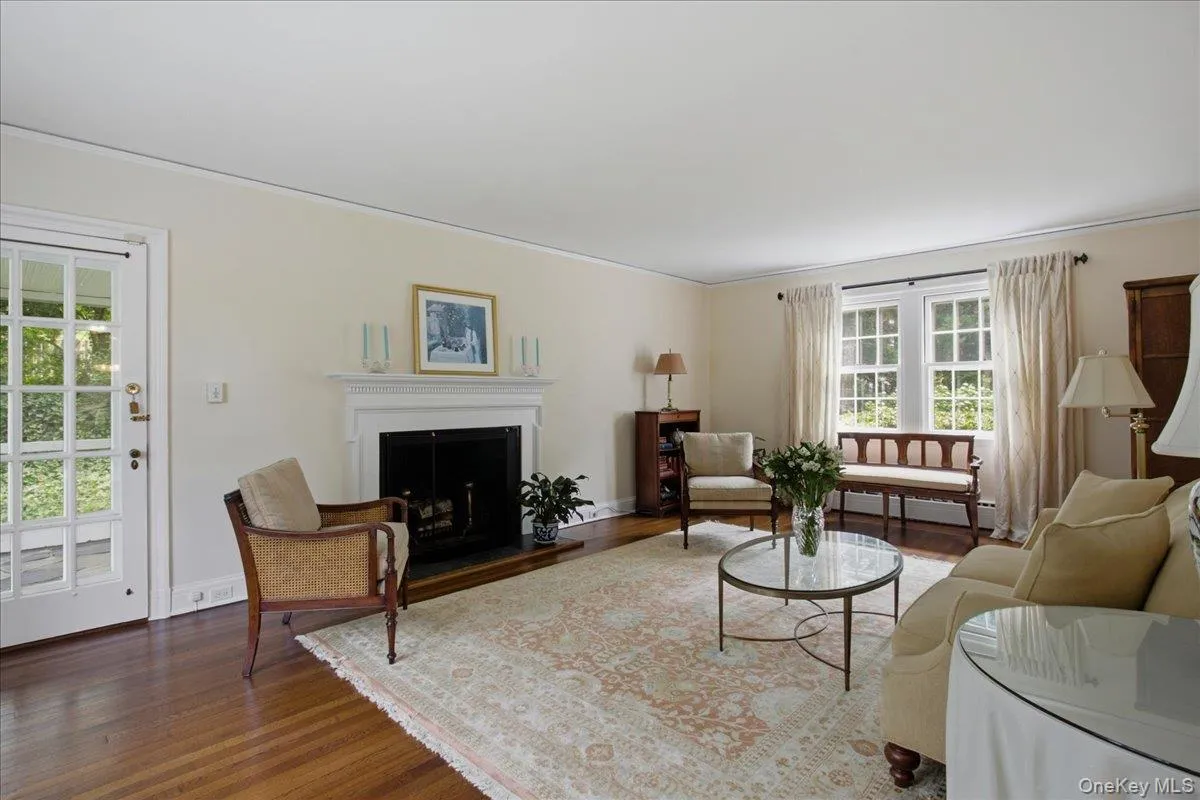 Living room featuring a fireplace with a white mantel, hearth, and dark firebox Living room featuring a fireplace with a white mantel, hearth, and dark firebox