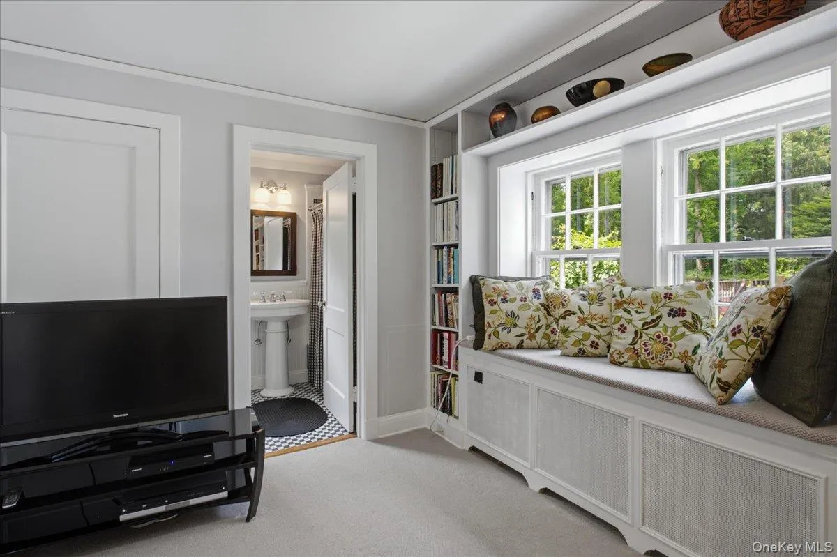 Built-in window seat with storage, integrated shelving, and two double-hung windows Built-in window seat with storage, integrated shelving, and two double-hung windows