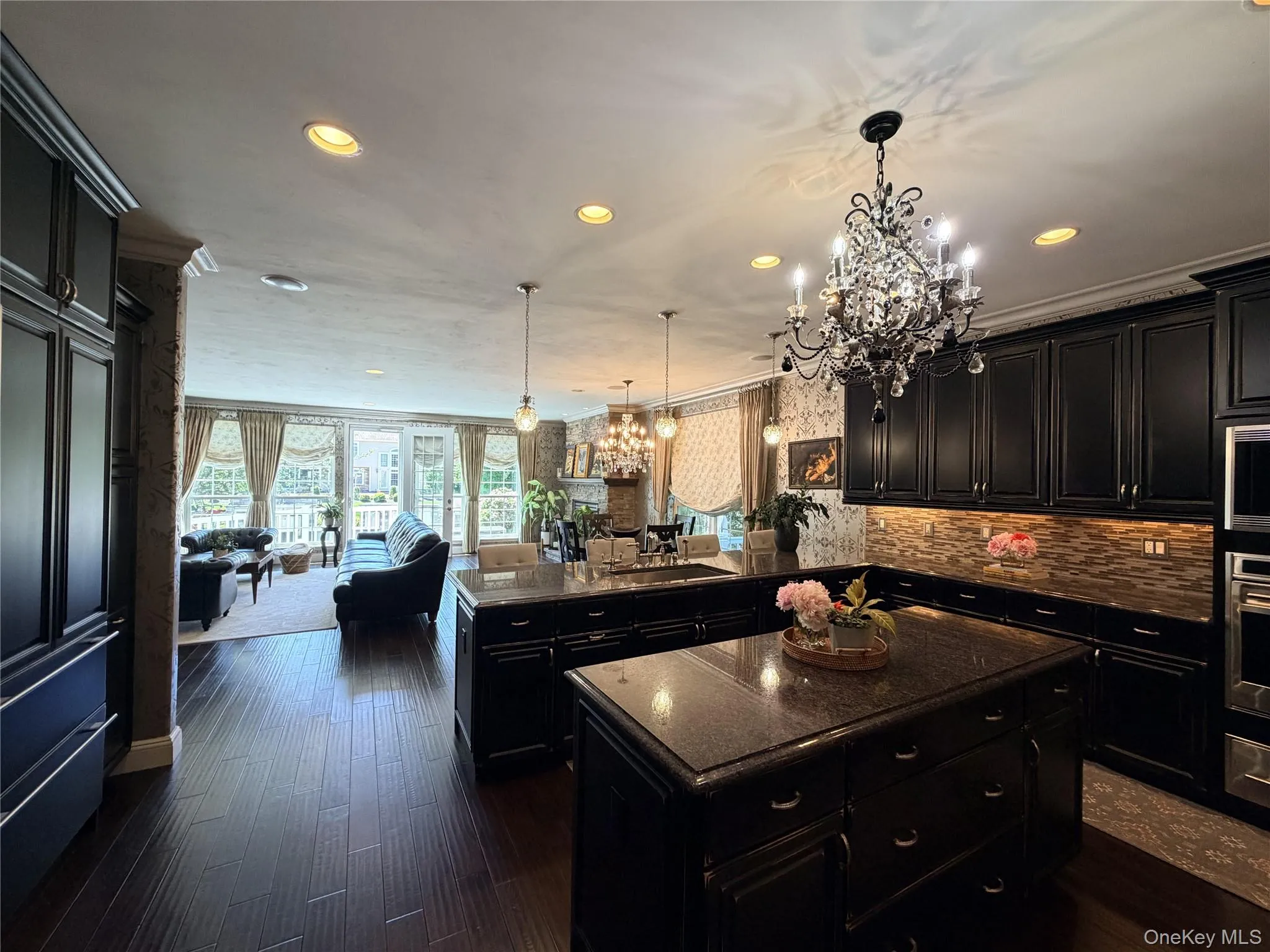 Gourmet kitchen featuring dark wood-finish cabinetry, granite countertops, and a full-height tile backsplash Gourmet kitchen featuring dark wood-finish cabinetry, granite countertops, and a full-height tile backsplash