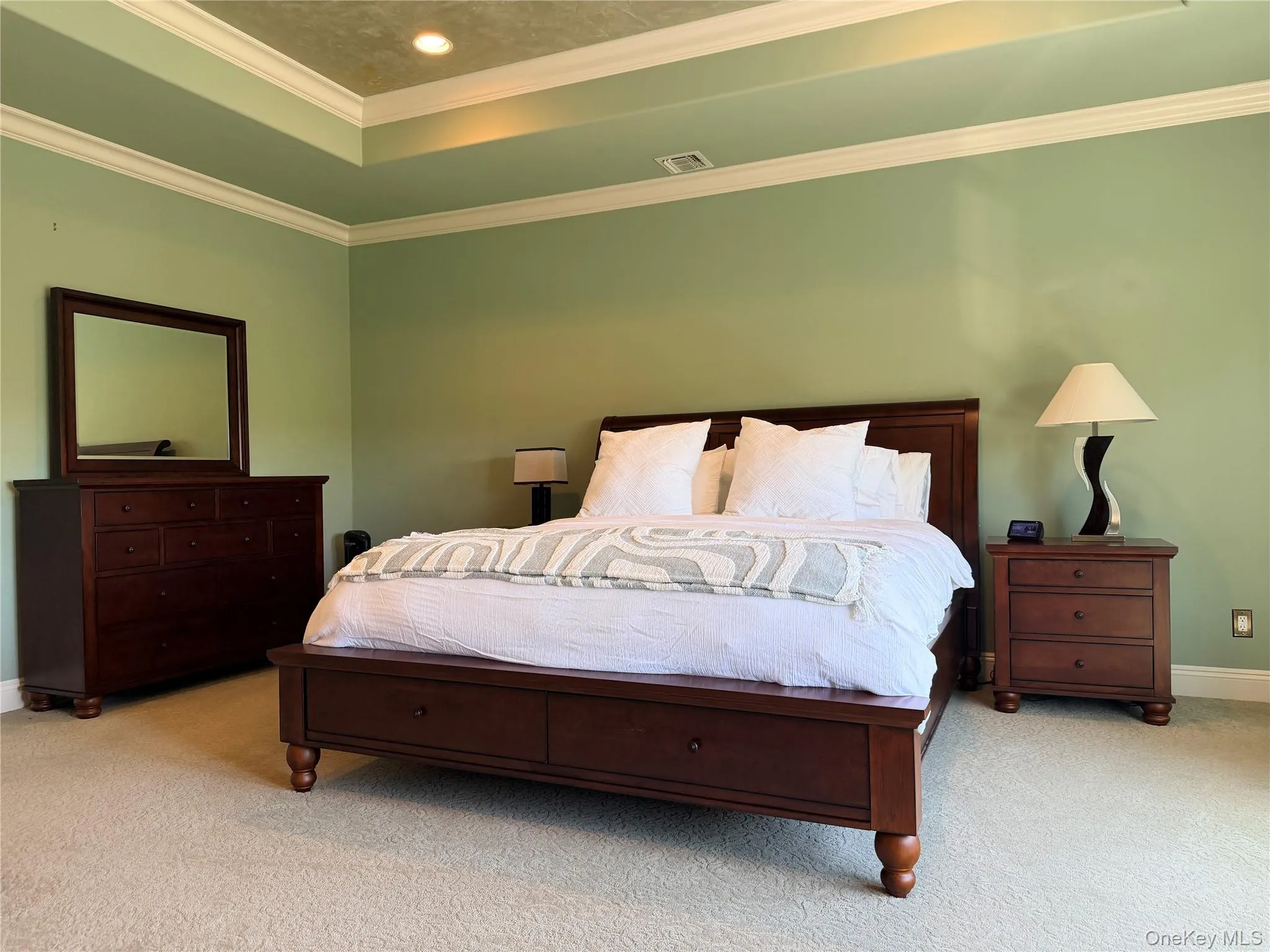 Principal bedroom featuring a tray ceiling with recessed lighting and crown molding Principal bedroom featuring a tray ceiling with recessed lighting and crown molding