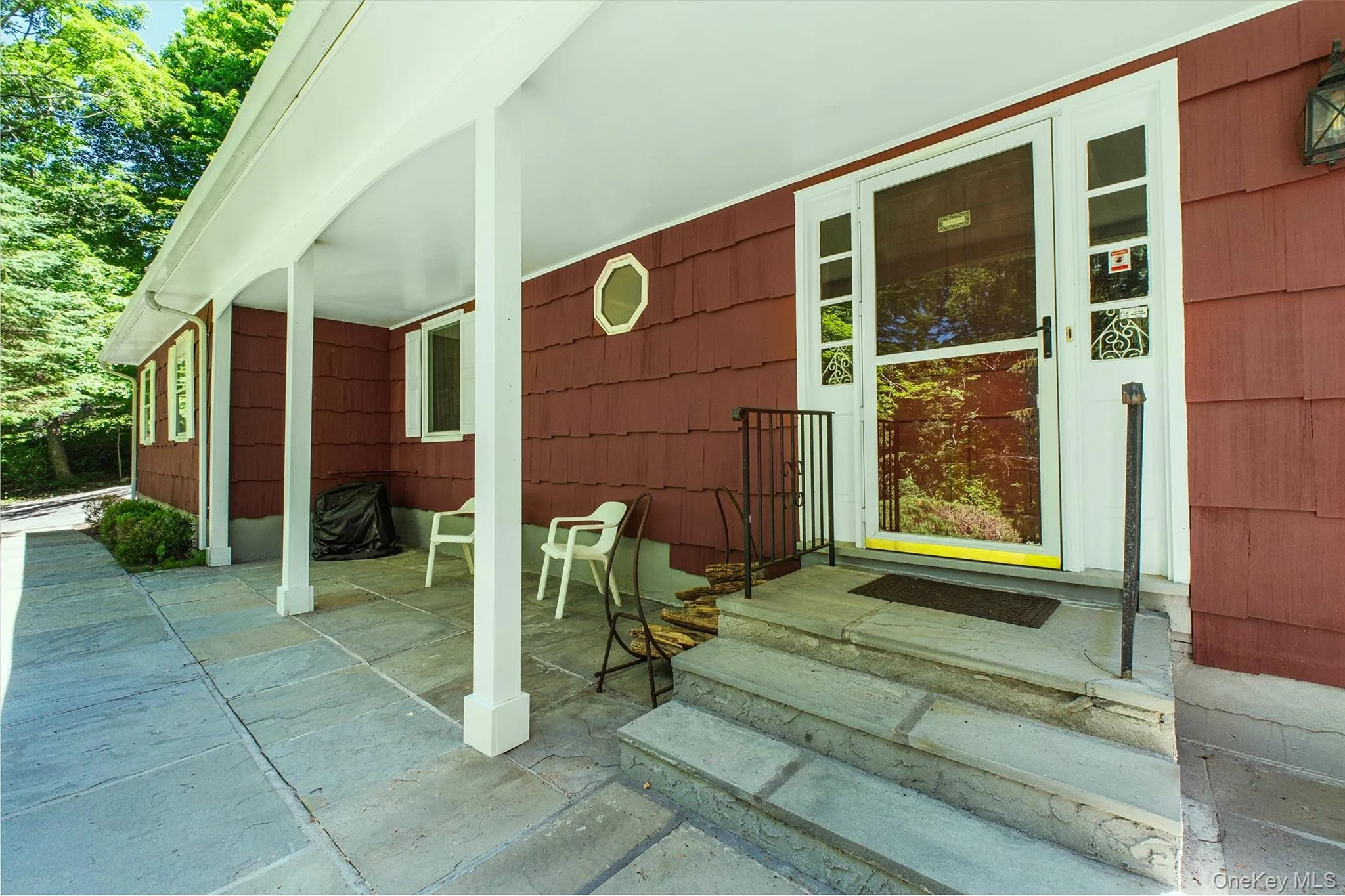 Covered front porch featuring a stone patio and steps to front door Covered front porch featuring a stone patio and steps to front door