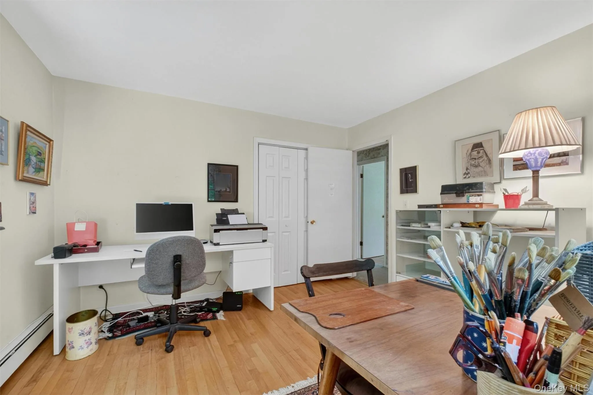 Bedroom #2 (used as office) w/light-toned walls, wood-finish flooring, two double-hung windows, and white trim baseboards Bedroom #2 (used as office) w/light-toned walls, wood-finish flooring, two double-hung windows, and white trim baseboards