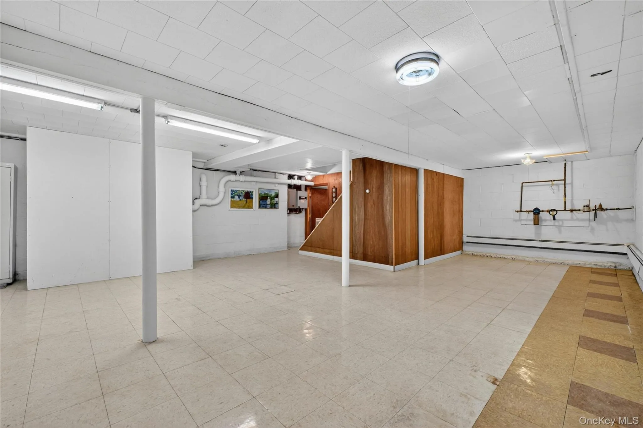 Versatile finished basement featuring a drop ceiling, exposed support beams, & tiled flooring, & electric heat. Versatile finished basement featuring a drop ceiling, exposed support beams, & tiled flooring, & electric heat.