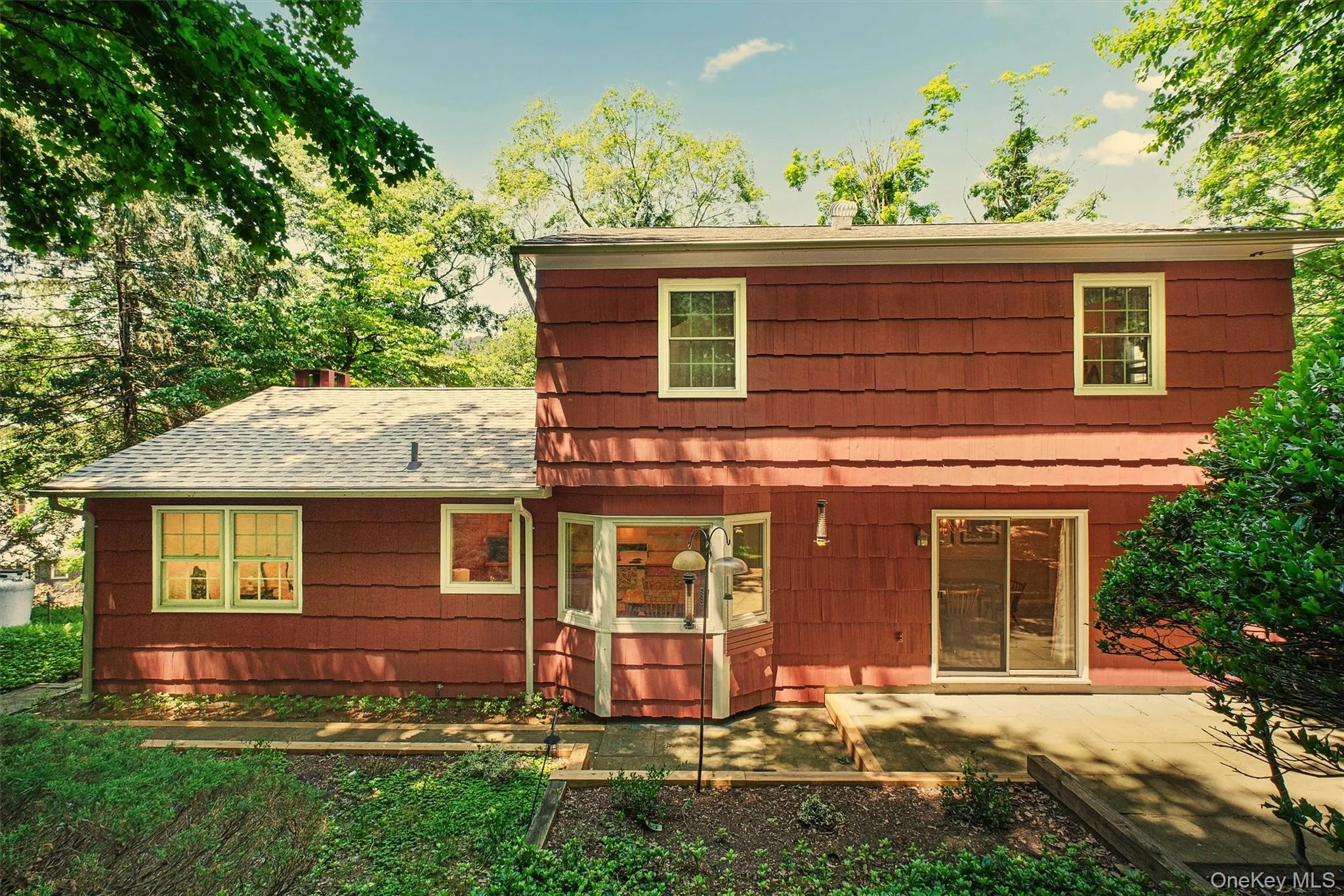 Rear view of house, patio, sliding glass doors from formal dining room with a multi-level roofline Rear view of house, patio, sliding glass doors from formal dining room with a multi-level roofline