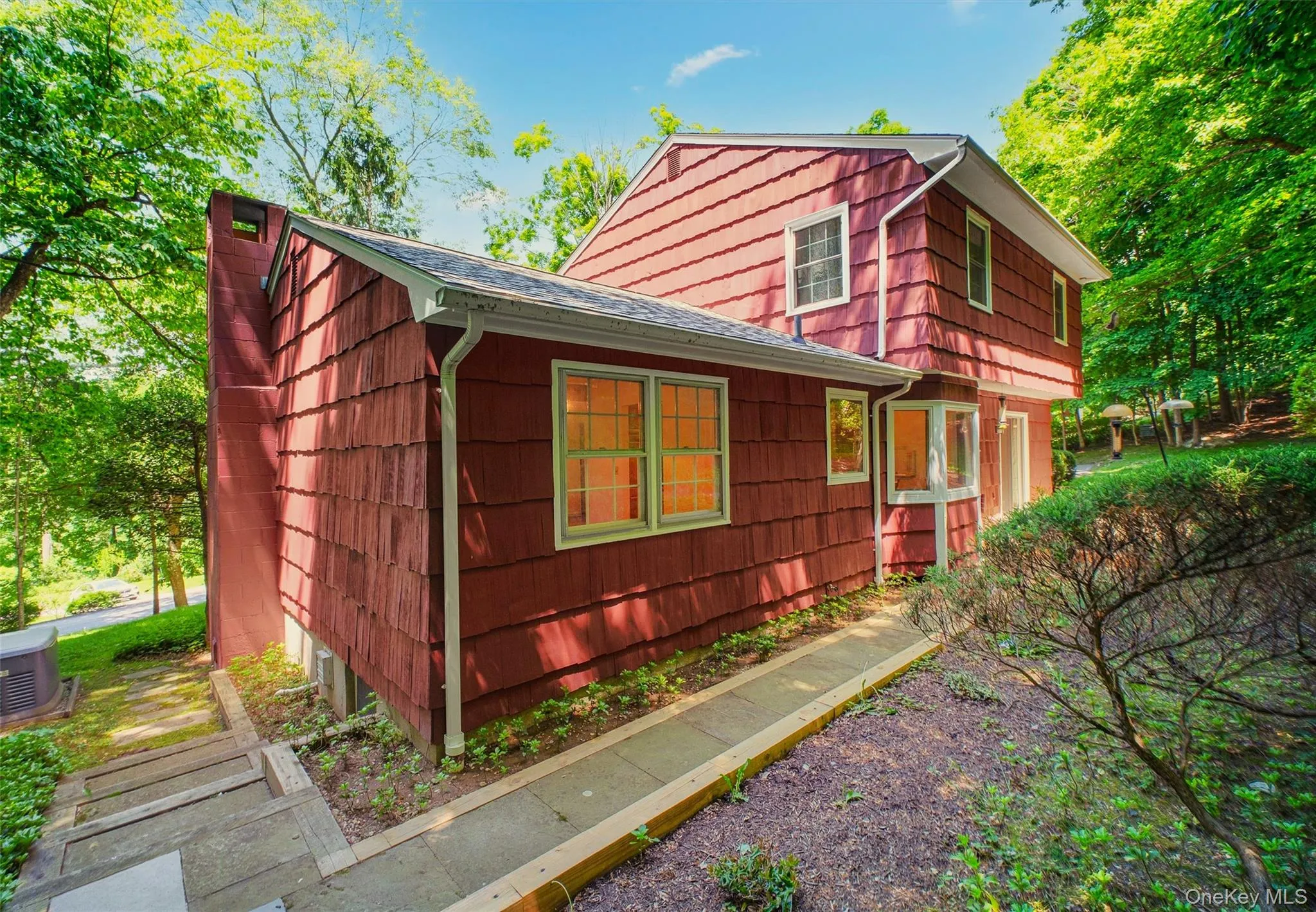 Red cedar shake siding with white trim w/blue stone walkway leading from rear patio to side yard Red cedar shake siding with white trim w/blue stone walkway leading from rear patio to side yard