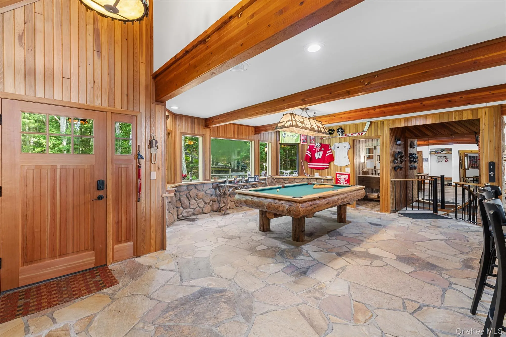Playroom with stone flooring, billiards table, wooden walls, beam ceiling, and recessed lighting Playroom with stone flooring, billiards table, wooden walls, beam ceiling, and recessed lighting