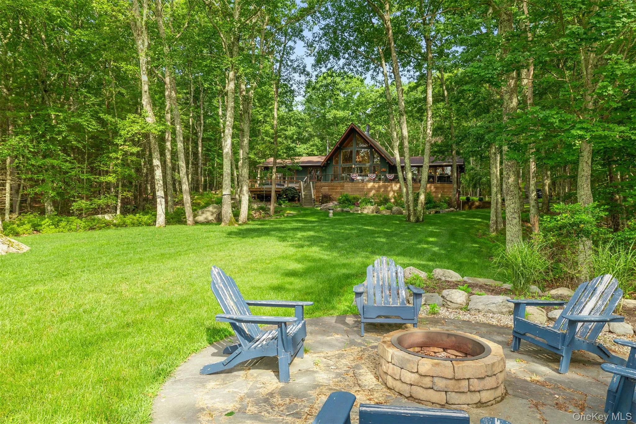 View of grassy yard with an outdoor fire pit and a patio area View of grassy yard with an outdoor fire pit and a patio area