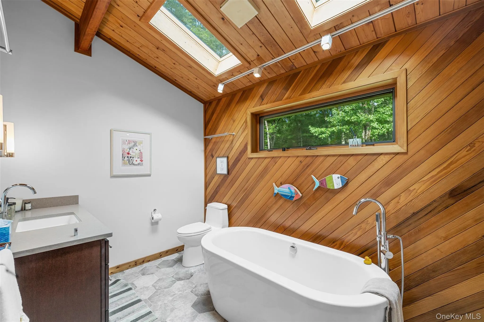 Bathroom with a skylight, a soaking tub, wood walls, wood ceiling, and vanity Bathroom with a skylight, a soaking tub, wood walls, wood ceiling, and vanity