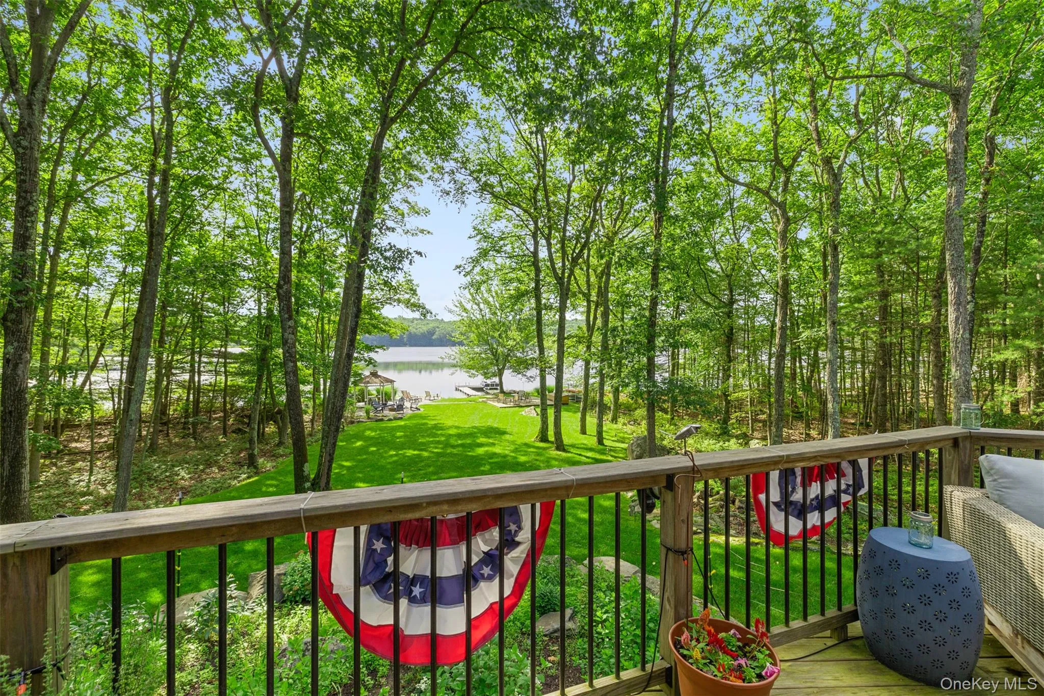 Wooden terrace with a water view and a lawn Wooden terrace with a water view and a lawn