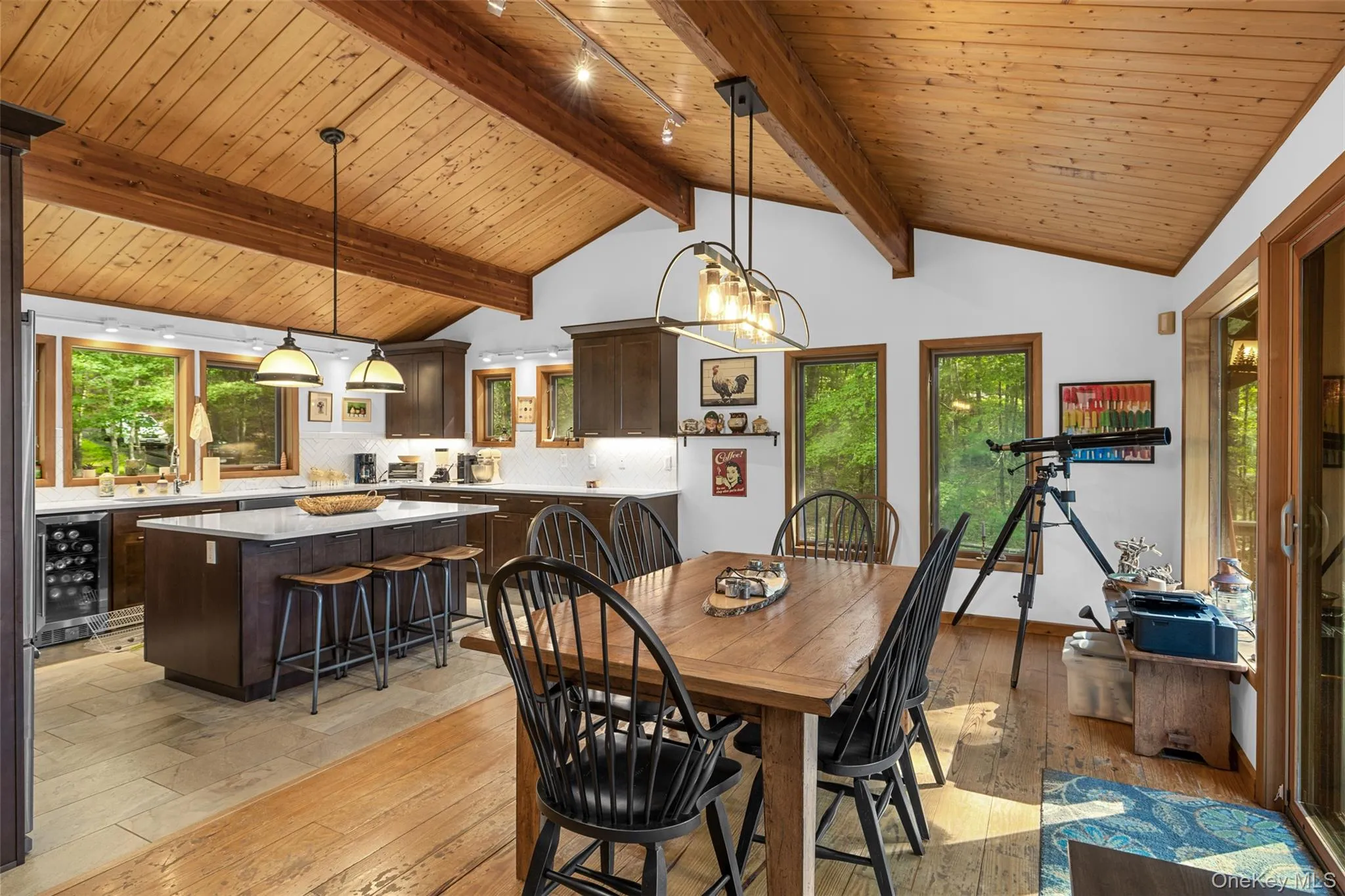 Dining space with beverage cooler, light wood finished floors, and wood ceiling Dining space with beverage cooler, light wood finished floors, and wood ceiling