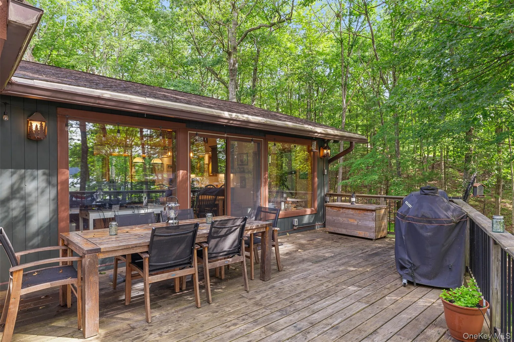 Wooden deck featuring a grill and outdoor dining area Wooden deck featuring a grill and outdoor dining area
