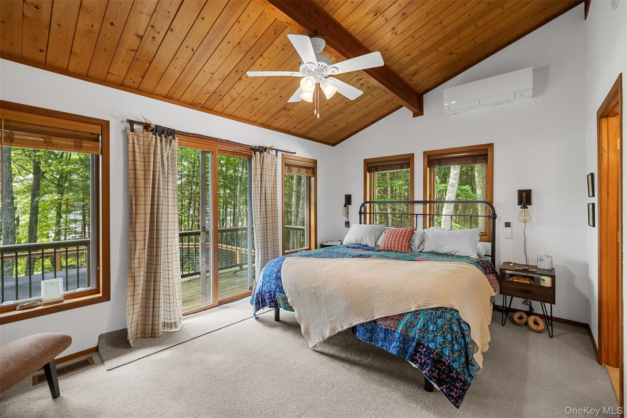 Bedroom with a wall unit AC, access to exterior, carpet flooring, multiple windows, and wooden ceiling Bedroom with a wall unit AC, access to exterior, carpet flooring, multiple windows, and wooden ceiling