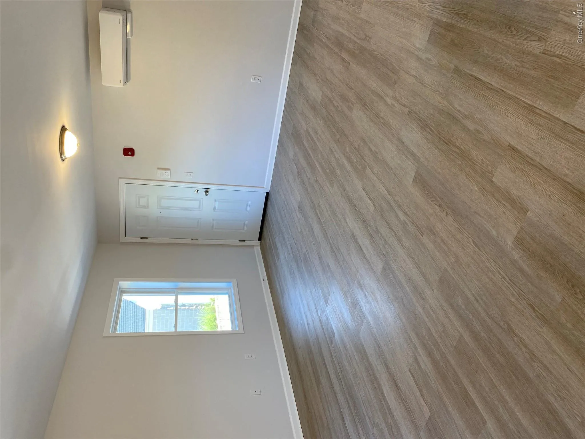 Spare room featuring wood finished floors and a wall mounted air conditioner Spare room featuring wood finished floors and a wall mounted air conditioner