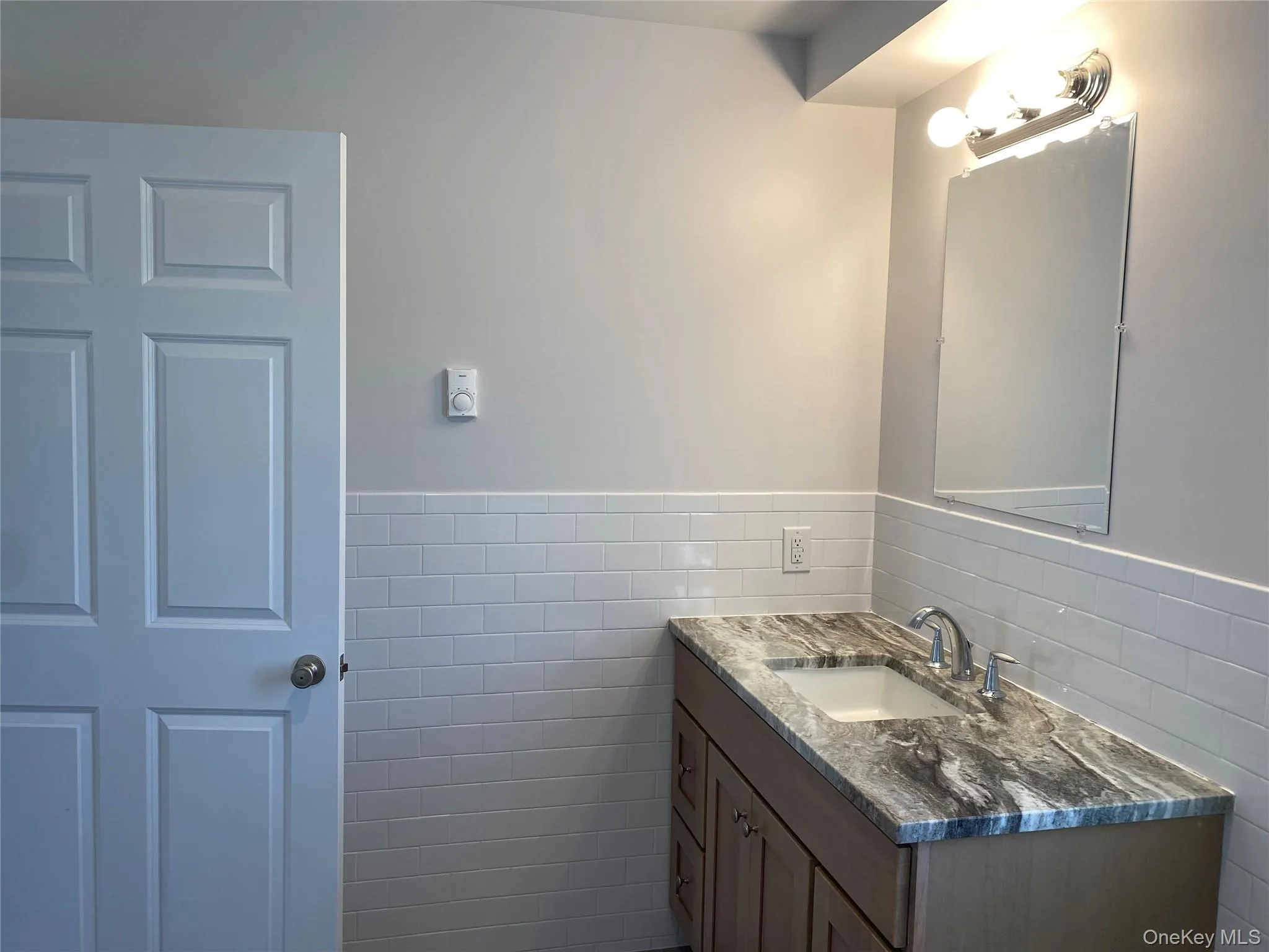 Bathroom featuring tile walls and vanity Bathroom featuring tile walls and vanity