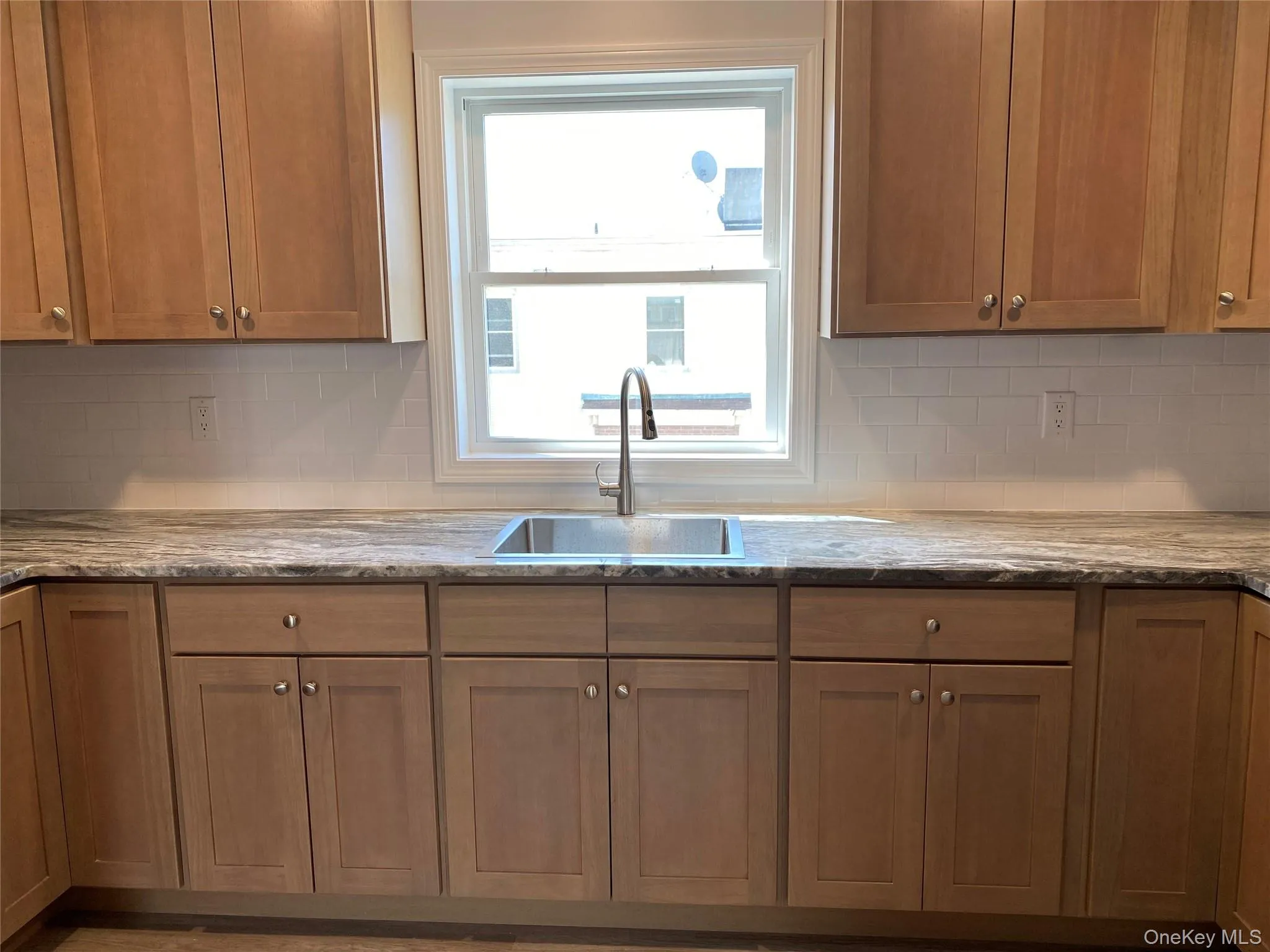 Kitchen with decorative backsplash, and light stone counters Kitchen with decorative backsplash, and light stone counters