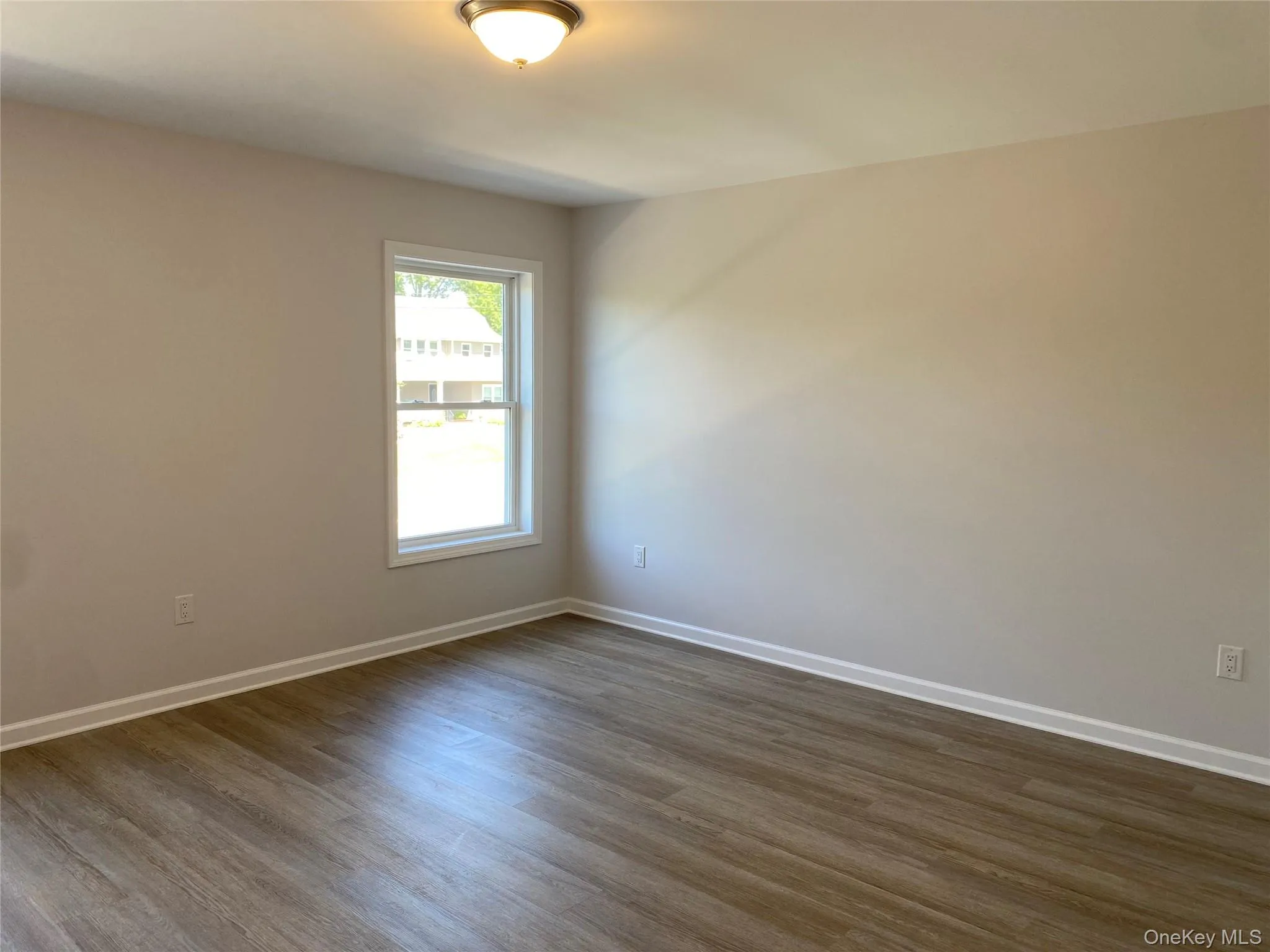 Empty room featuring dark wood-type flooring and baseboards Empty room featuring dark wood-type flooring and baseboards