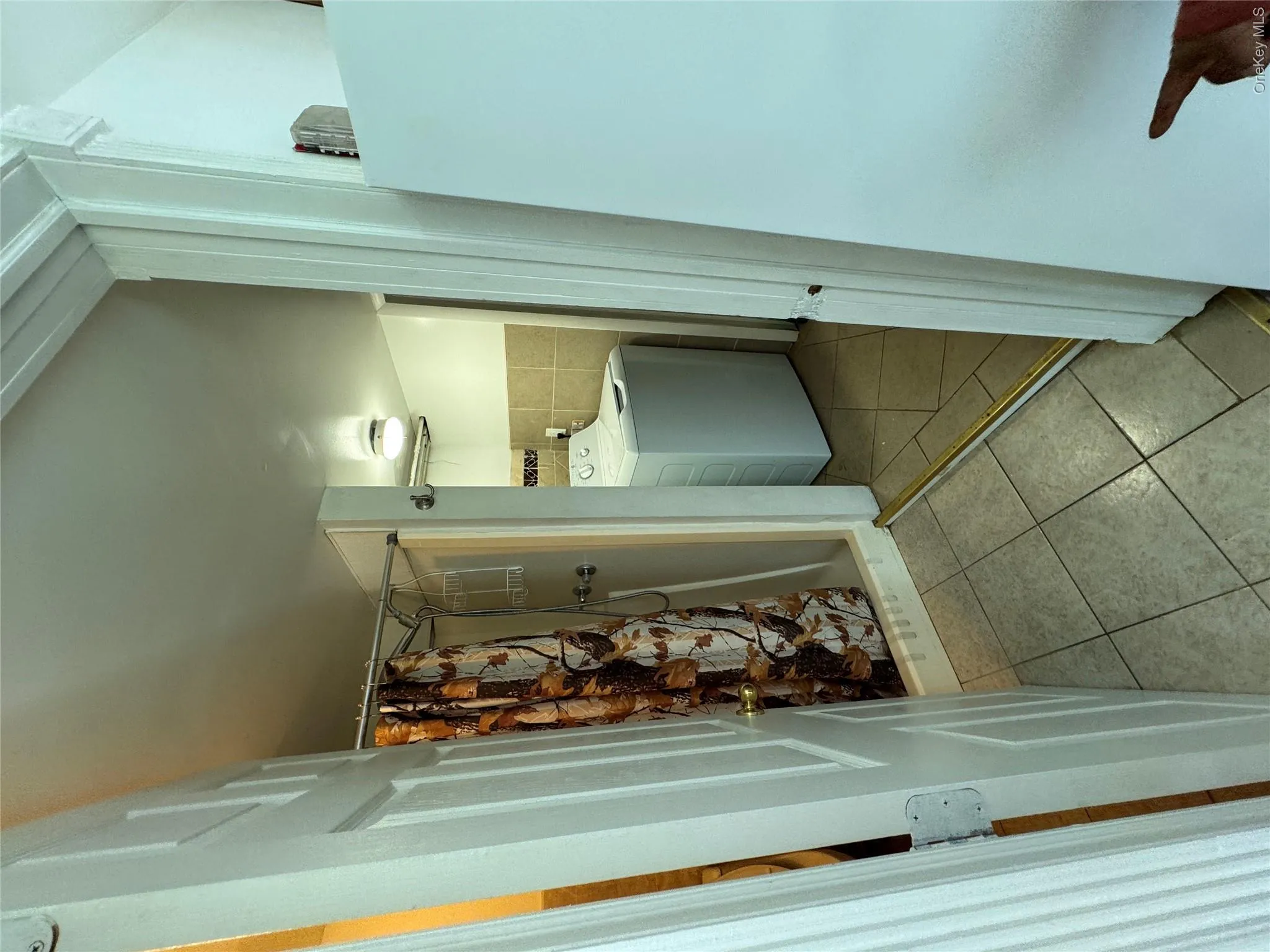 Full bath with standing shower and washing machine. Full bath with standing shower and washing machine.