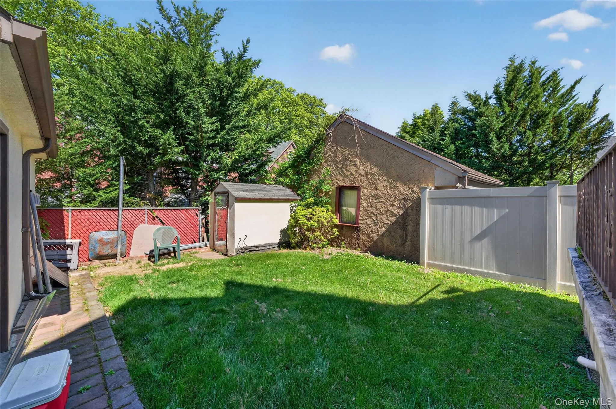 Expansive grassy yard with a paver patio and privacy fencing Expansive grassy yard with a paver patio and privacy fencing