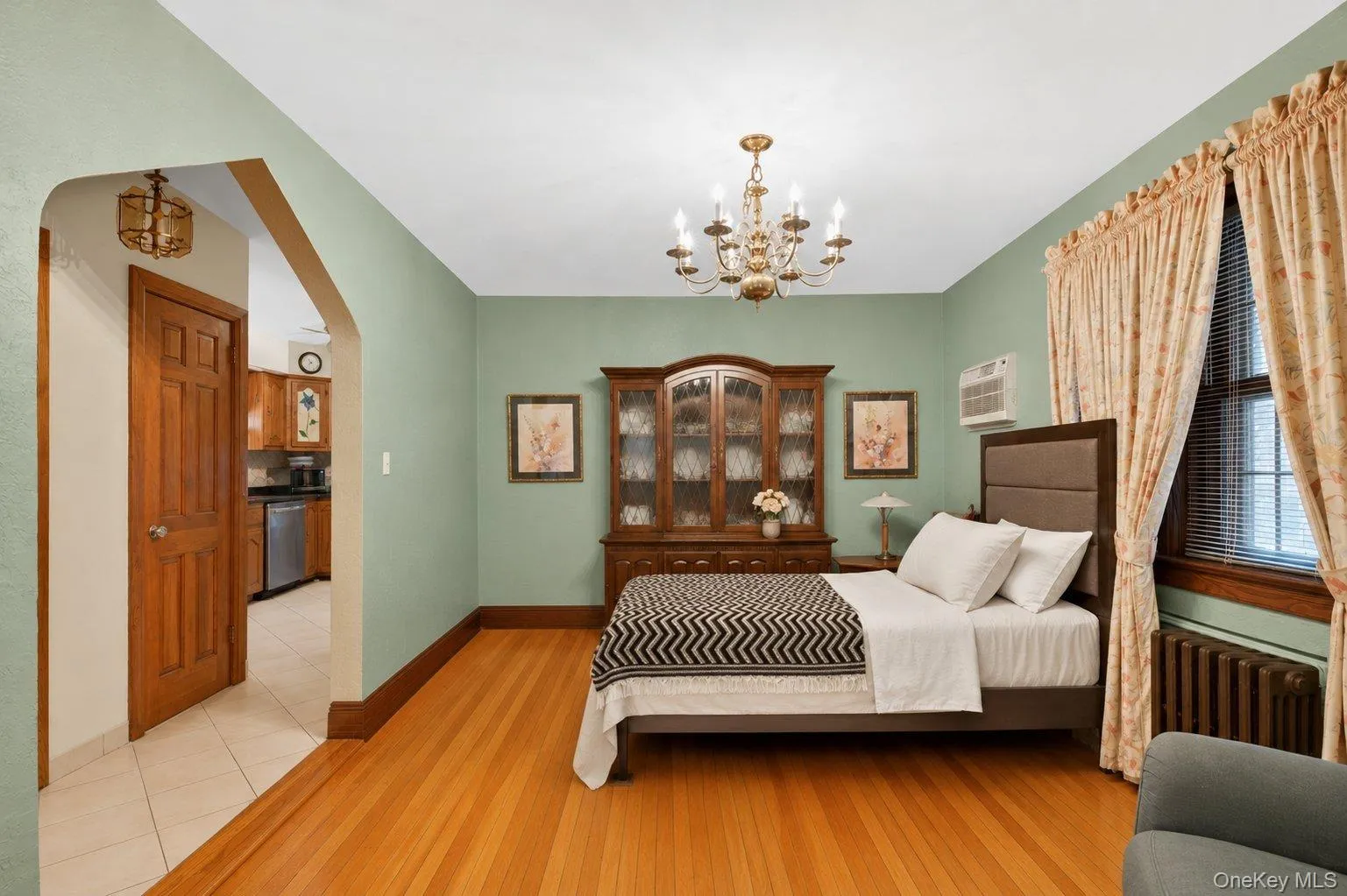 Hardwood flooring throughout, complemented by a brass chandelier and detailed window trim Hardwood flooring throughout, complemented by a brass chandelier and detailed window trim