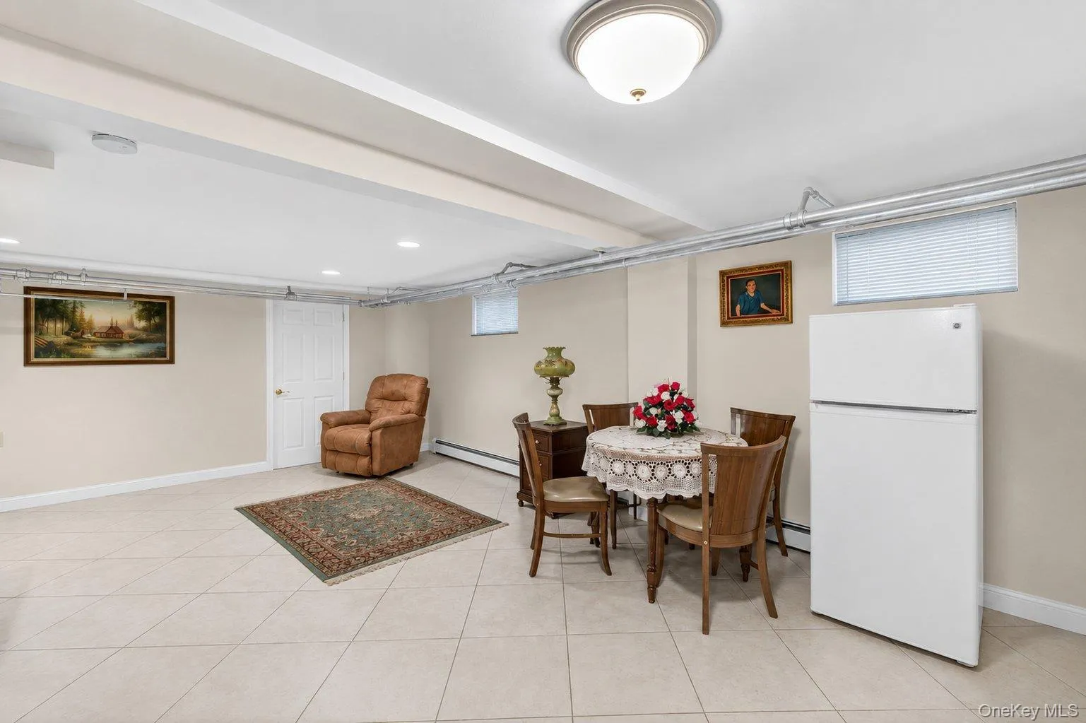 Spacious lower level featuring light-toned tile flooring throughout, multiple recessed lighting fixtures, and a ceiling-mounted light fixture Spacious lower level featuring light-toned tile flooring throughout, multiple recessed lighting fixtures, and a ceiling-mounted light fixture