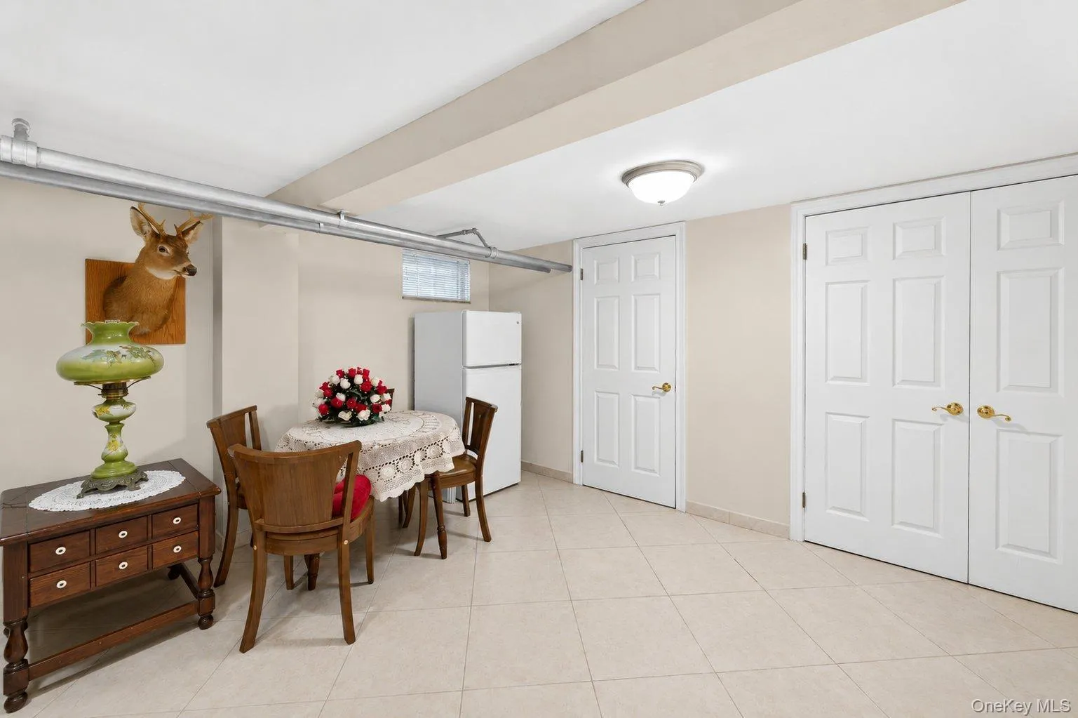 Spacious room featuring light-toned tile flooring, neutral wall paint, and white trim Spacious room featuring light-toned tile flooring, neutral wall paint, and white trim