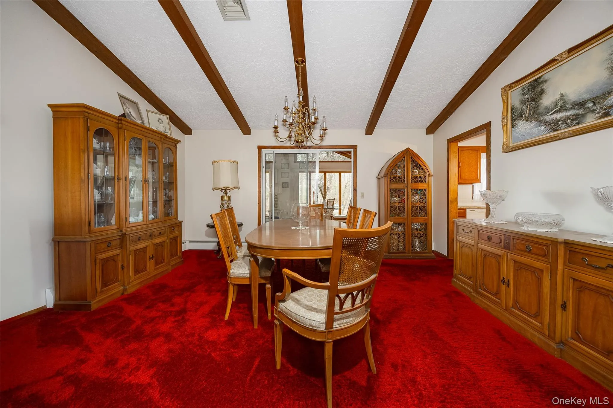 Dining space with a chandelier, a textured ceiling, and dark colored carpet Dining space with a chandelier, a textured ceiling, and dark colored carpet