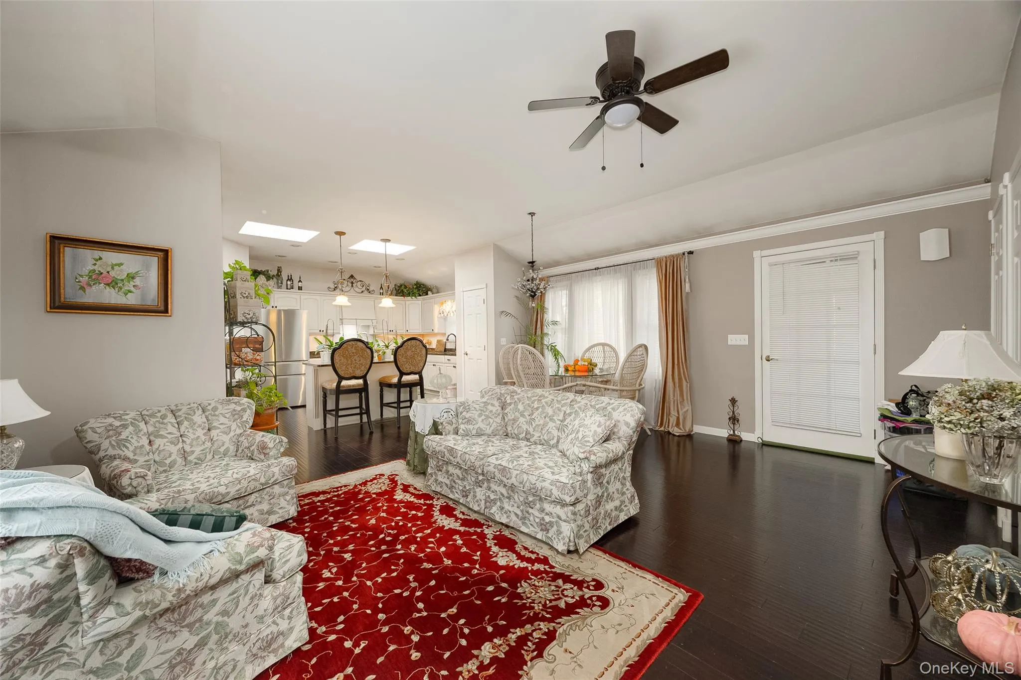 Living area with dark wood finished floors, a skylight, and ceiling fan Living area with dark wood finished floors, a skylight, and ceiling fan
