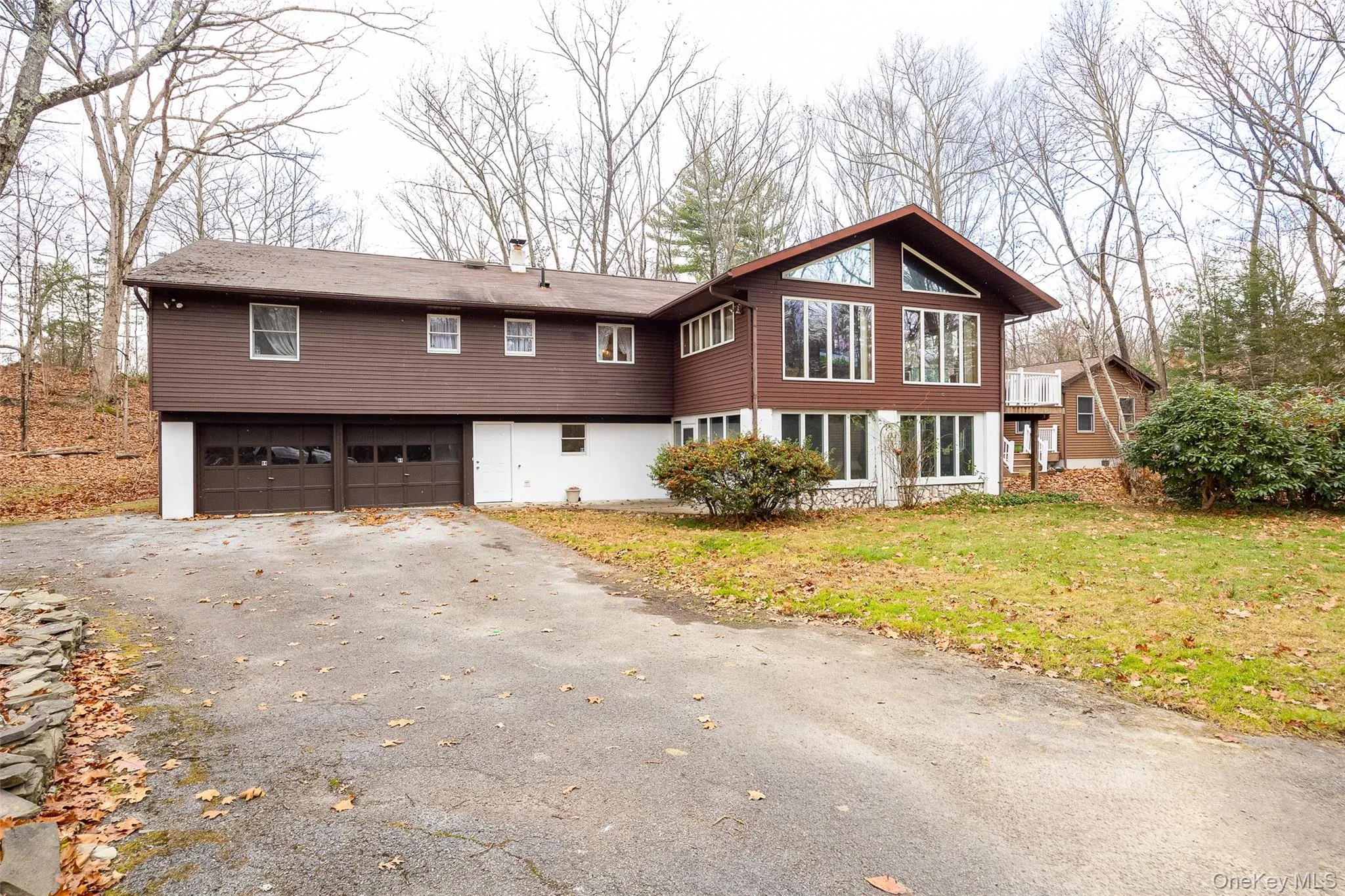 View of front of home featuring a front yard, asphalt driveway, and a garage View of front of home featuring a front yard, asphalt driveway, and a garage
