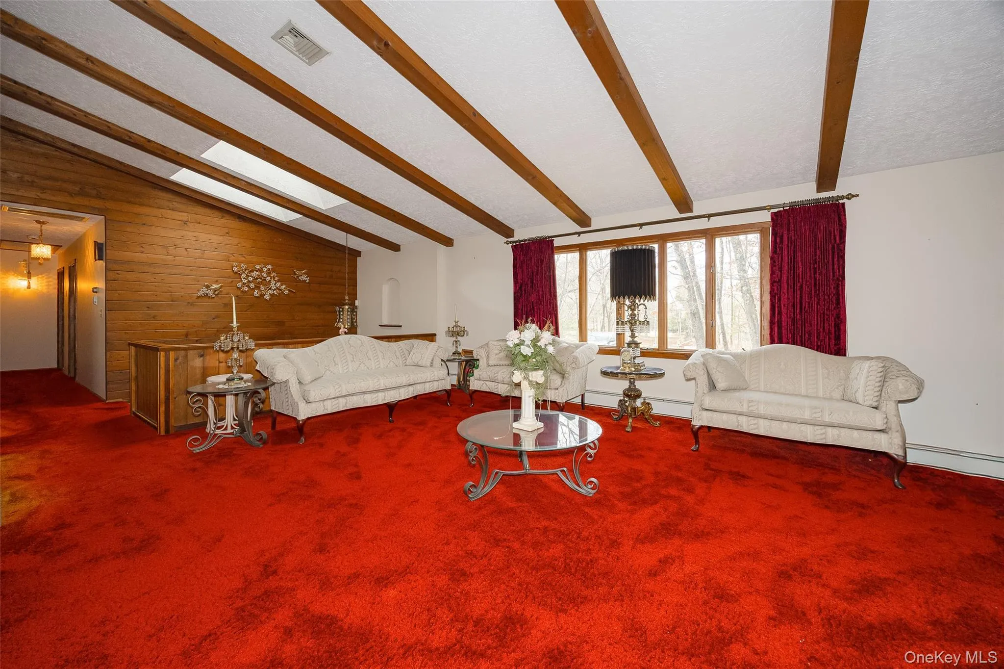 Living area with wooden walls and carpet flooring Living area with wooden walls and carpet flooring