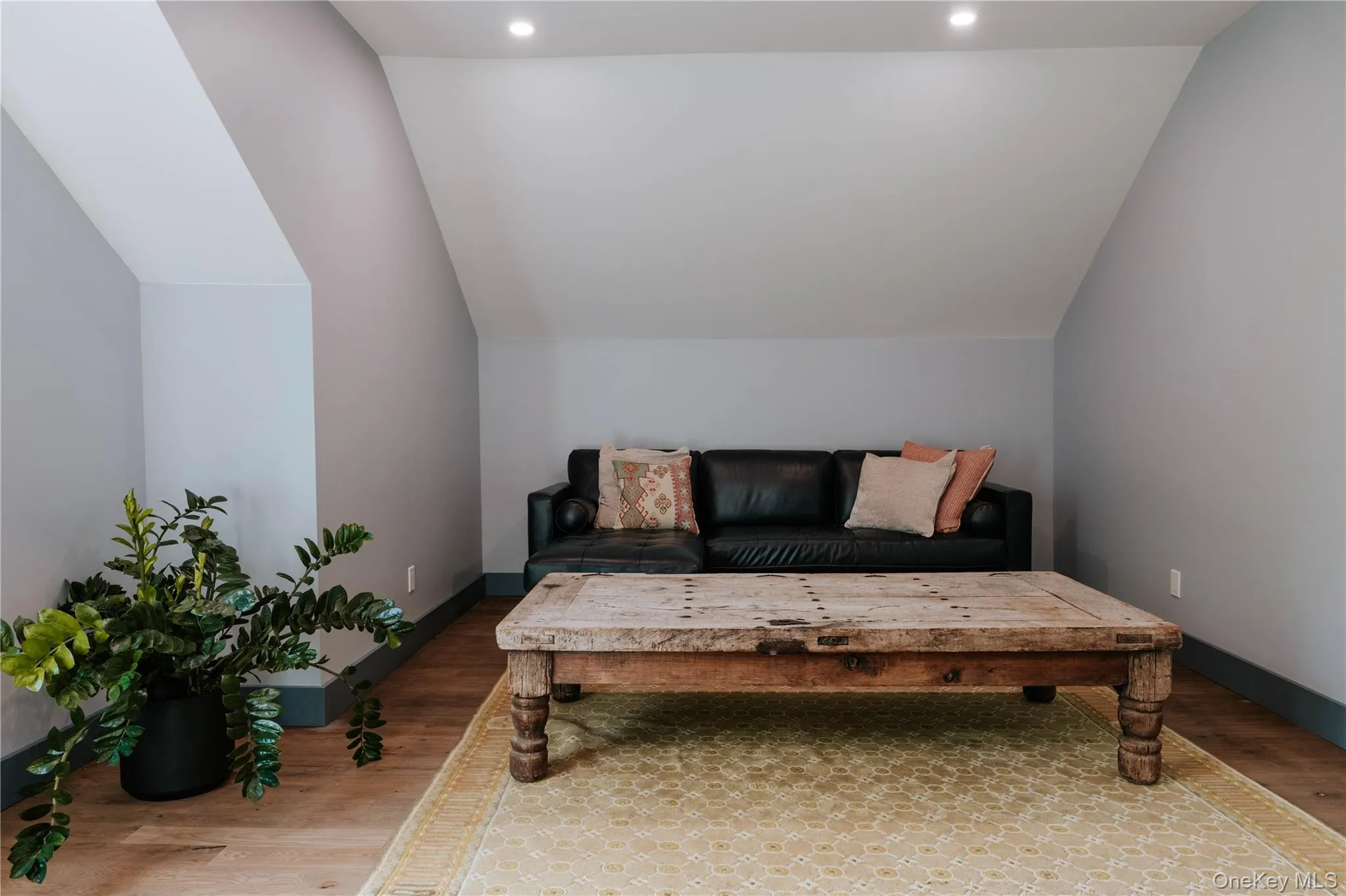 Living area with wood finished floors, vaulted ceiling, and recessed lighting Living area with wood finished floors, vaulted ceiling, and recessed lighting