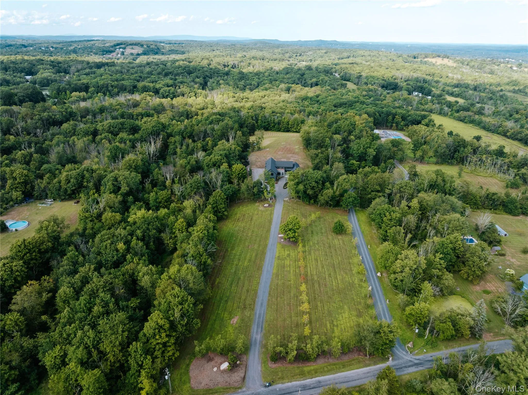 Aerial view of property and surrounding area with a forest Aerial view of property and surrounding area with a forest
