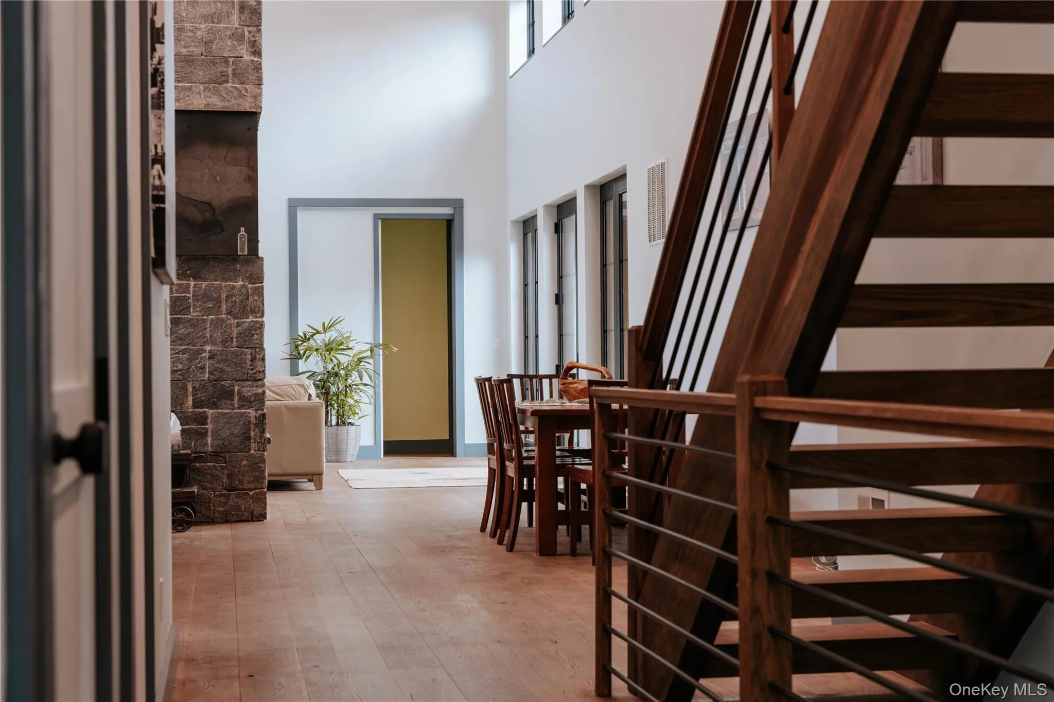 Corridor featuring wood-type flooring and a towering ceiling Corridor featuring wood-type flooring and a towering ceiling