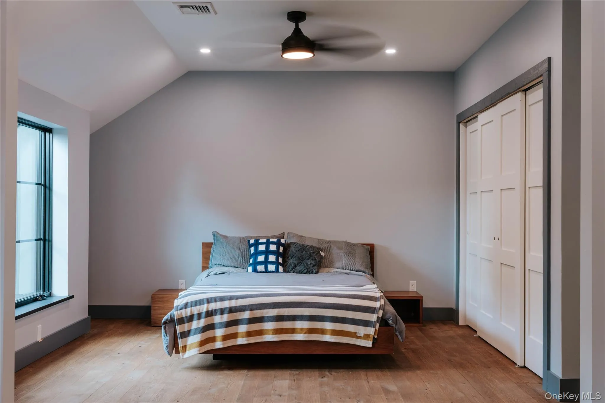 Bedroom with wood finished floors, lofted ceiling, a closet, a ceiling fan, and recessed lighting Bedroom with wood finished floors, lofted ceiling, a closet, a ceiling fan, and recessed lighting