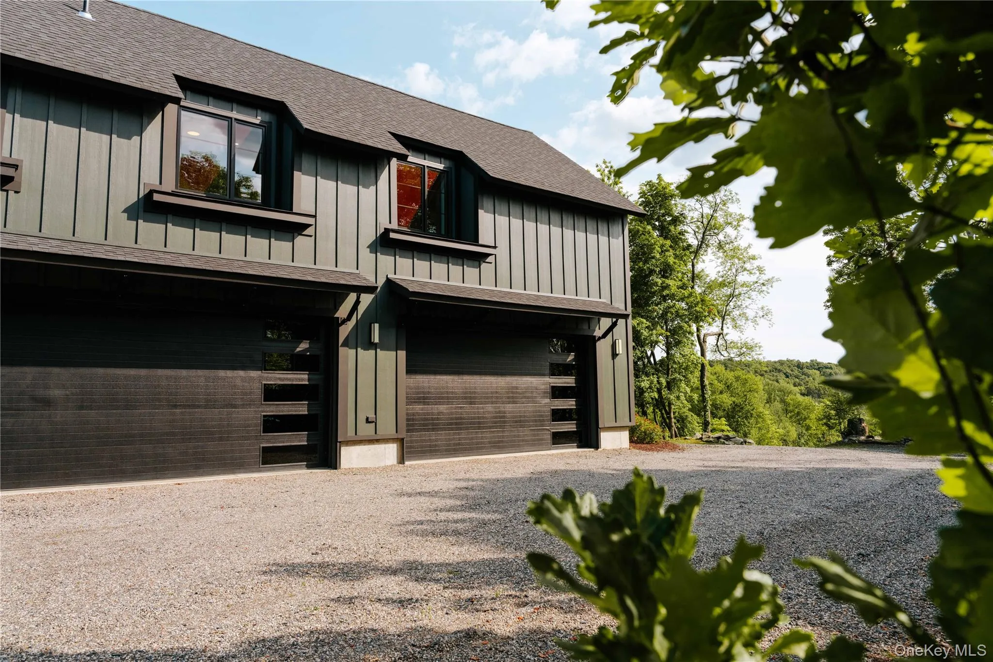 View of front of property featuring board and batten siding, a garage, roof with shingles, and driveway View of front of property featuring board and batten siding, a garage, roof with shingles, and driveway